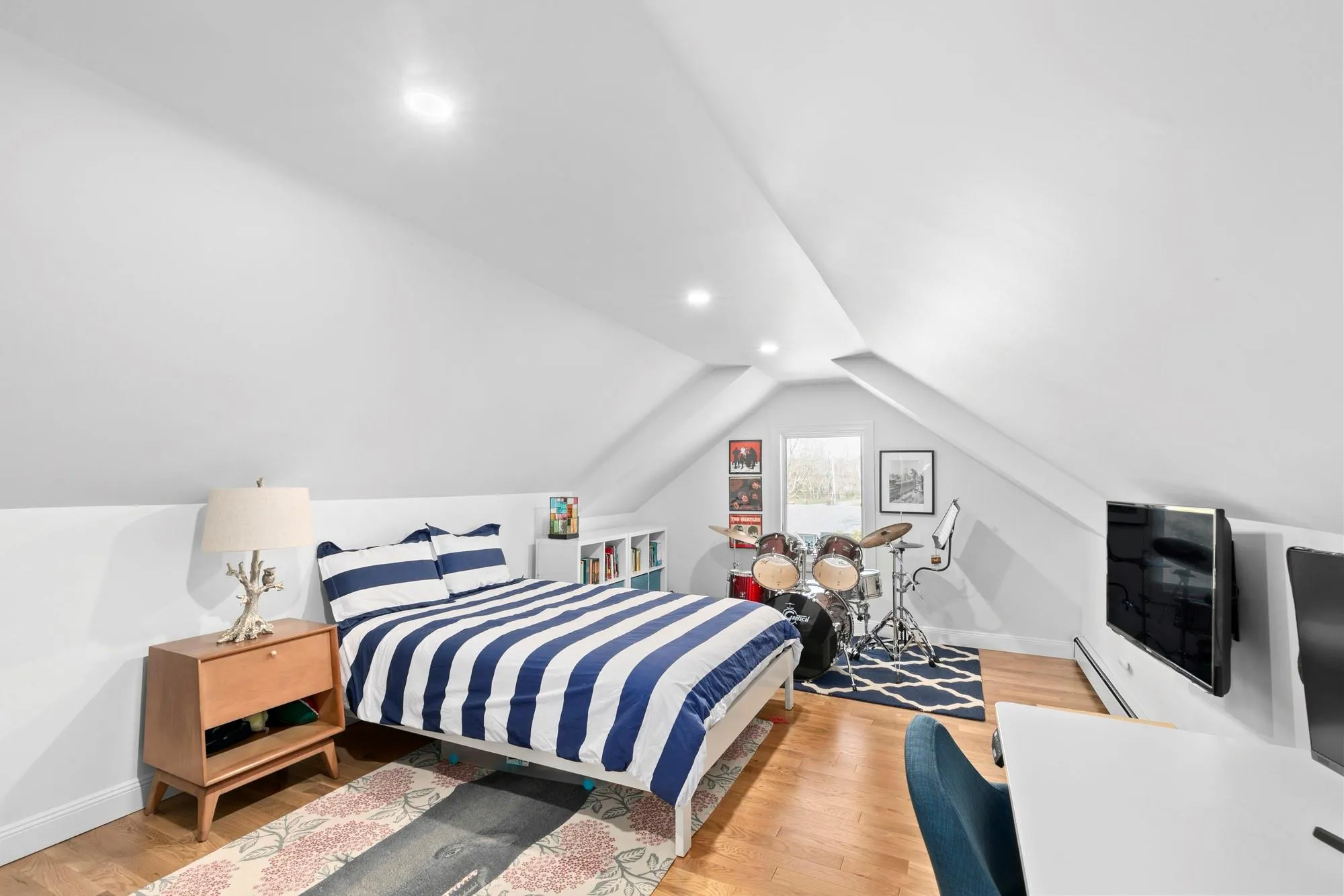 Bedroom featuring vaulted ceiling, light wood-style flooring, and baseboards Bedroom featuring vaulted ceiling, light wood-style flooring, and baseboards