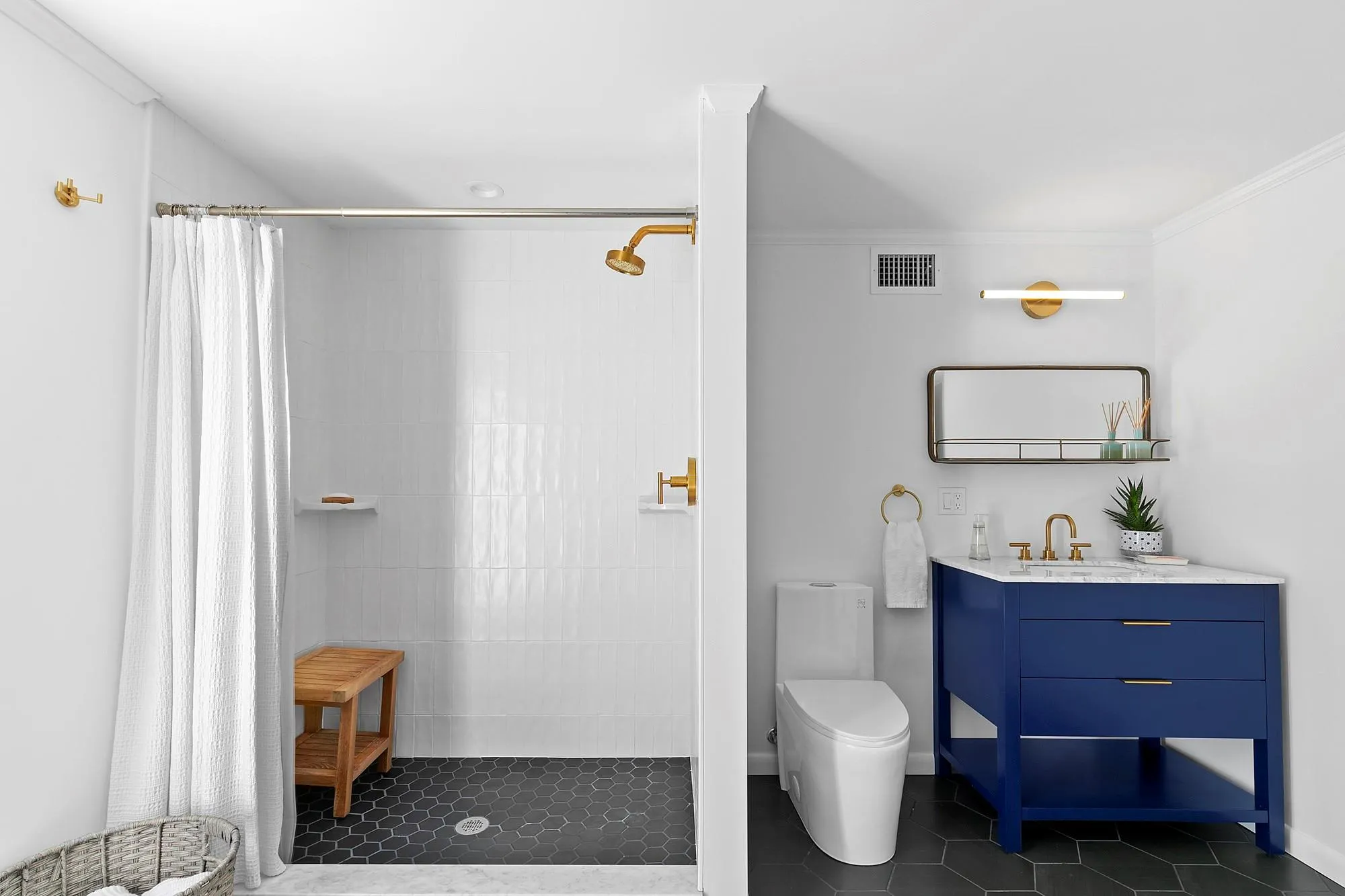 Bathroom featuring vanity, visible vents, tiled shower, tile patterned flooring, and toilet Bathroom featuring vanity, visible vents, tiled shower, tile patterned flooring, and toilet