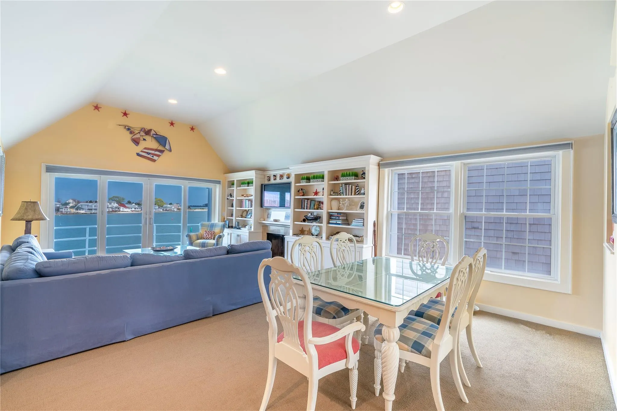 Carpeted dining area featuring recessed lighting, a fireplace, baseboards, and vaulted ceiling Carpeted dining area featuring recessed lighting, a fireplace, baseboards, and vaulted ceiling