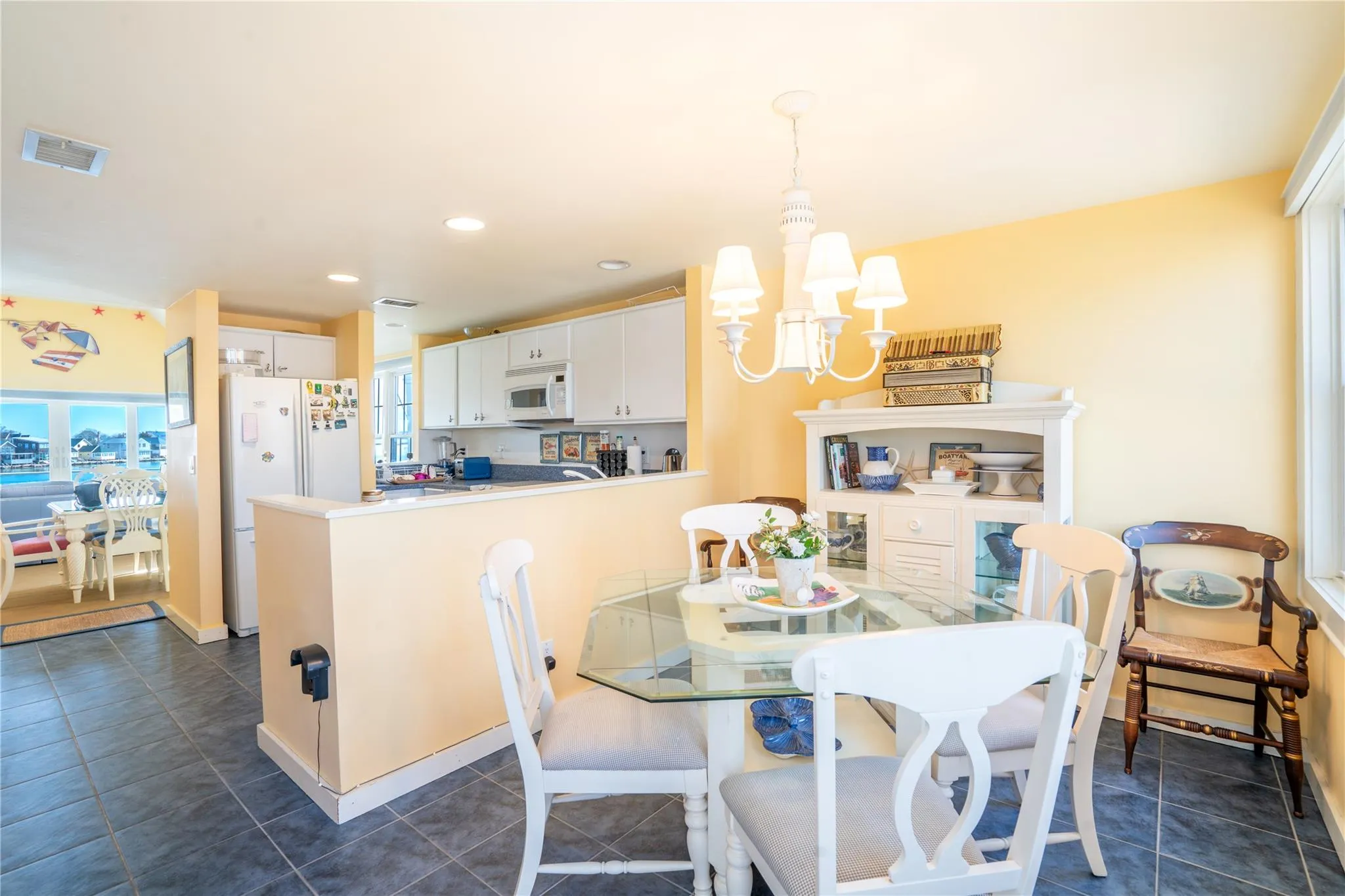 Dining space with visible vents, baseboards, dark tile patterned flooring, recessed lighting, and a notable chandelier Dining space with visible vents, baseboards, dark tile patterned flooring, recessed lighting, and a notable chandelier