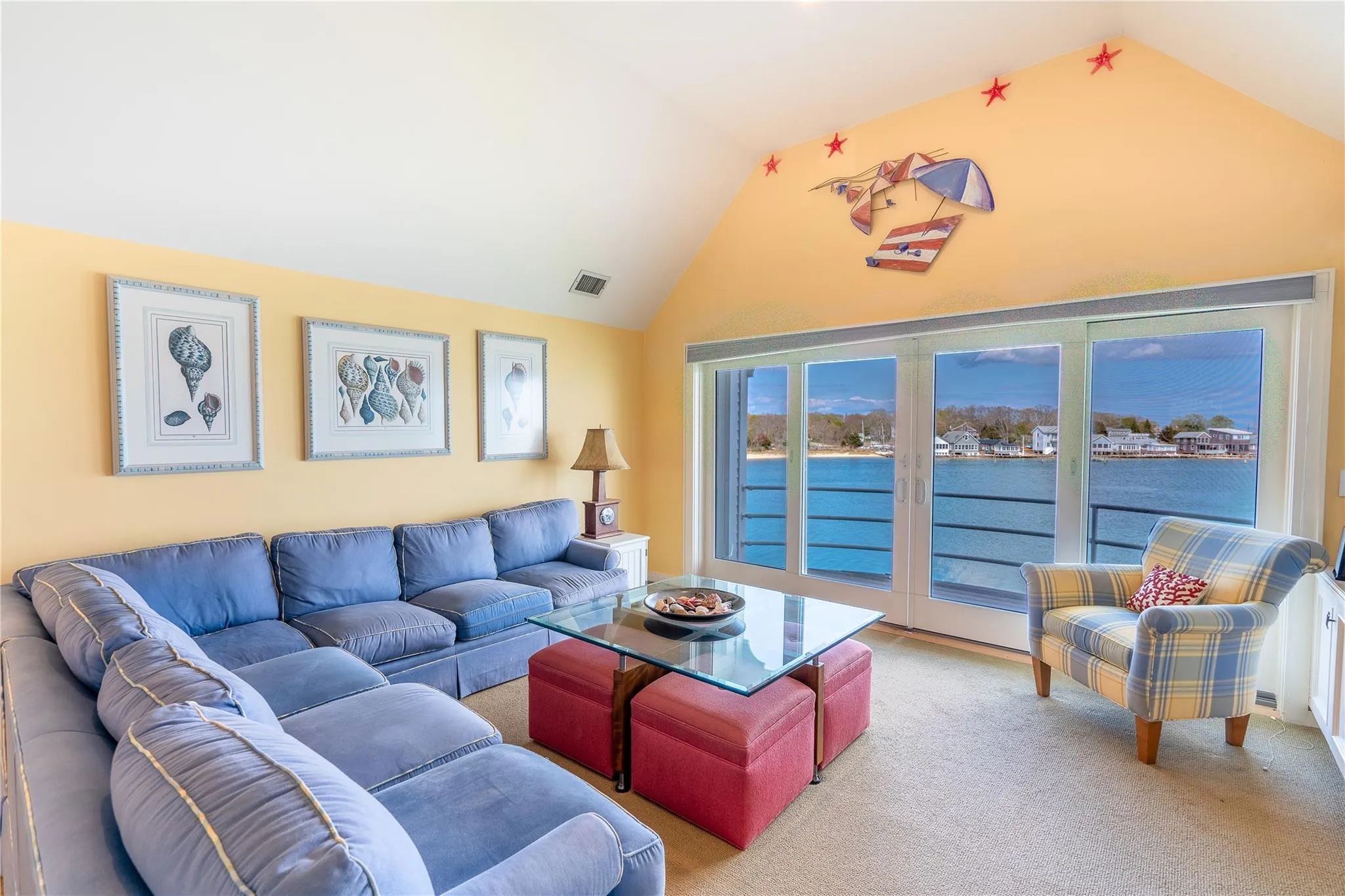 Living area with carpet flooring, visible vents, lofted ceiling, and a water view Living area with carpet flooring, visible vents, lofted ceiling, and a water view