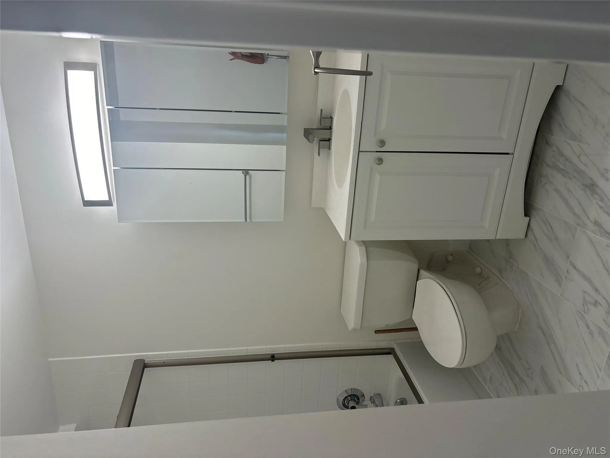 Bathroom featuring vanity, marble finish floors, washtub / shower combination, and plenty of natural light Bathroom featuring vanity, marble finish floors, washtub / shower combination, and plenty of natural light