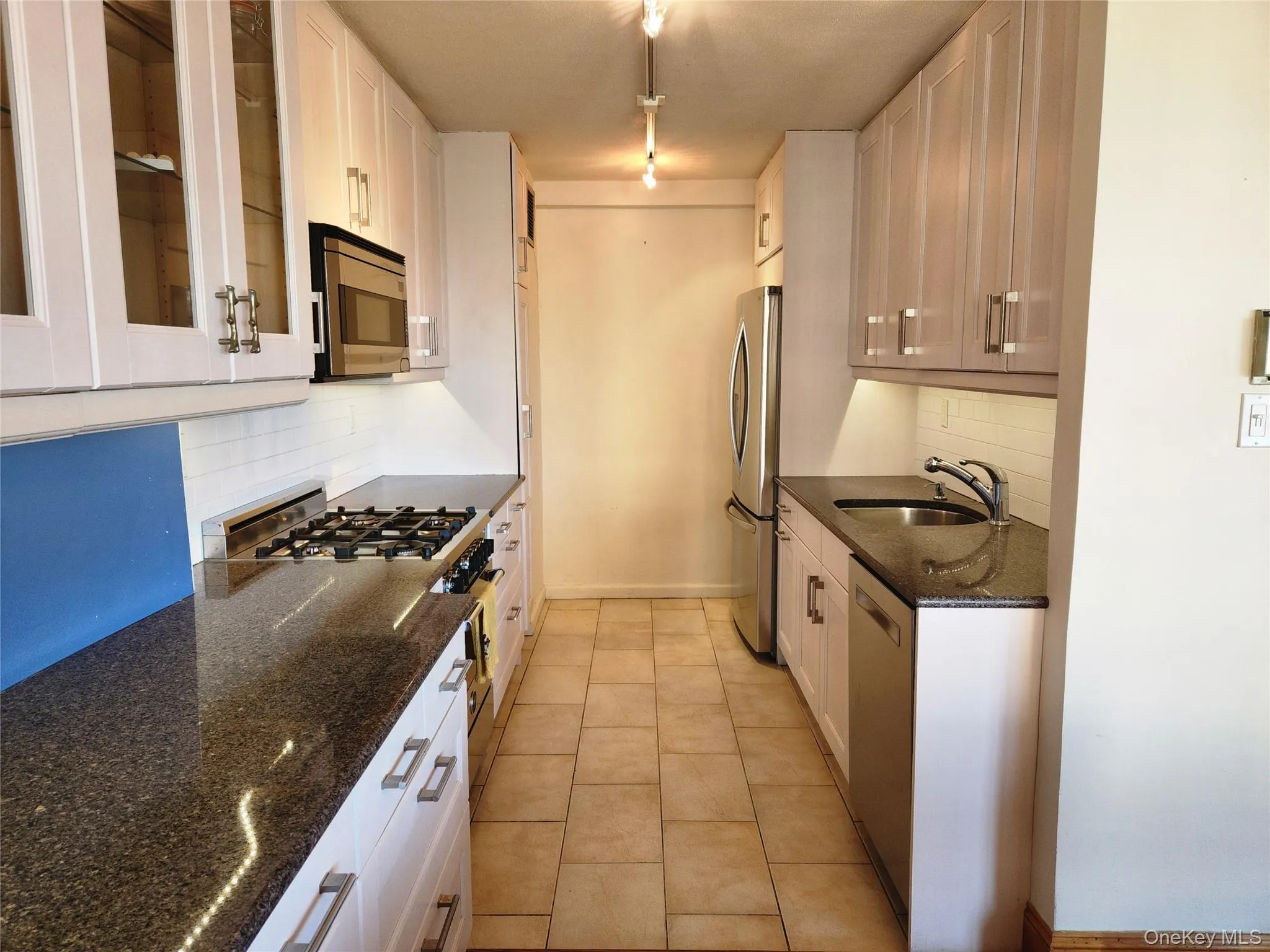 Kitchen with a sink, stainless steel appliances, and white cabinets Kitchen with a sink, stainless steel appliances, and white cabinets