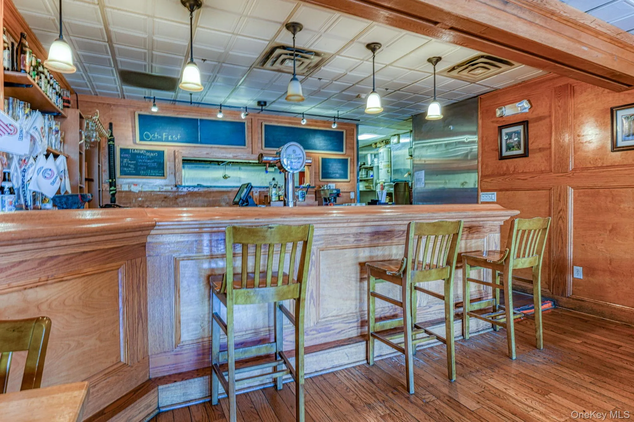 Bar featuring indoor wet bar, wood walls, and wood finished floors Bar featuring indoor wet bar, wood walls, and wood finished floors
