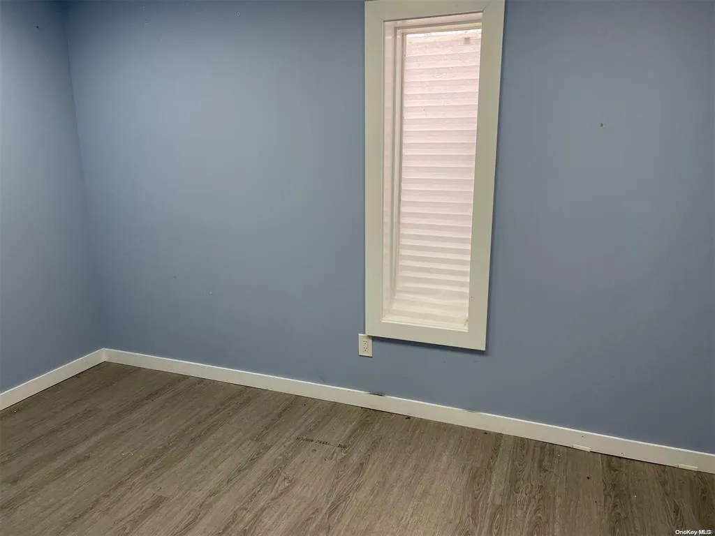 Spare room featuring wood finished floors and baseboards Spare room featuring wood finished floors and baseboards
