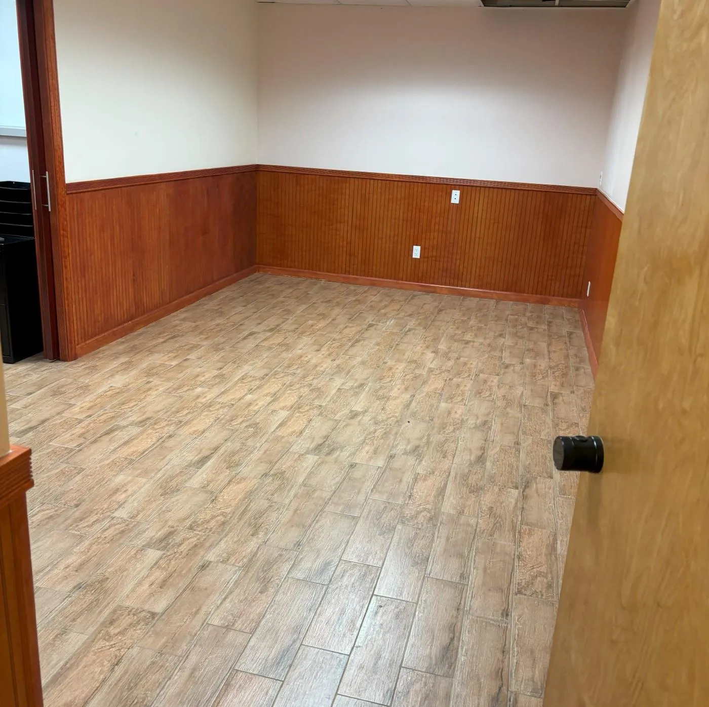 Empty room with a wainscoted wall, wood walls, and light wood-style floors Empty room with a wainscoted wall, wood walls, and light wood-style floors