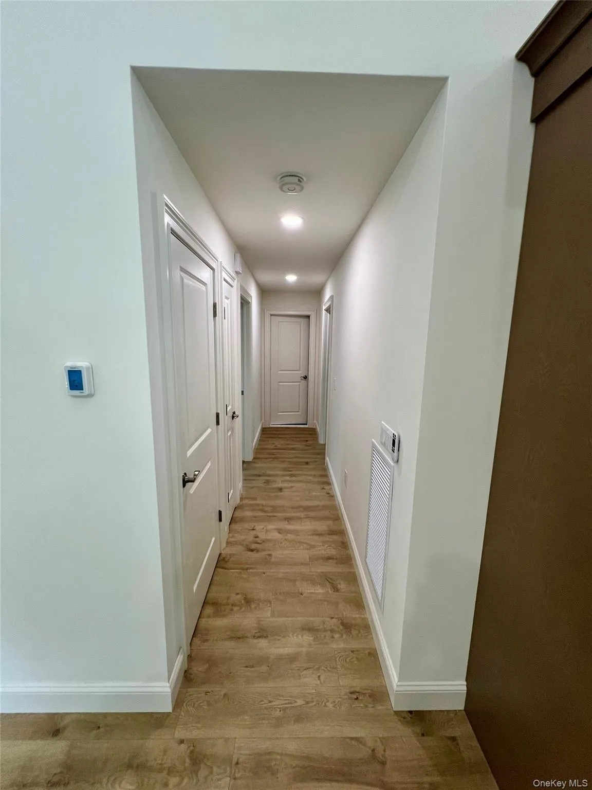 Hallway with baseboards and light wood-style floors Hallway with baseboards and light wood-style floors