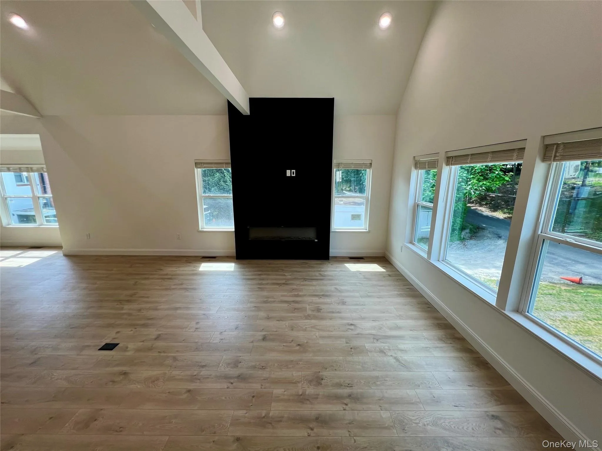 Unfurnished living room featuring plenty of natural light, light wood-style flooring, high vaulted ceiling, and recessed lighting Unfurnished living room featuring plenty of natural light, light wood-style flooring, high vaulted ceiling, and recessed lighting