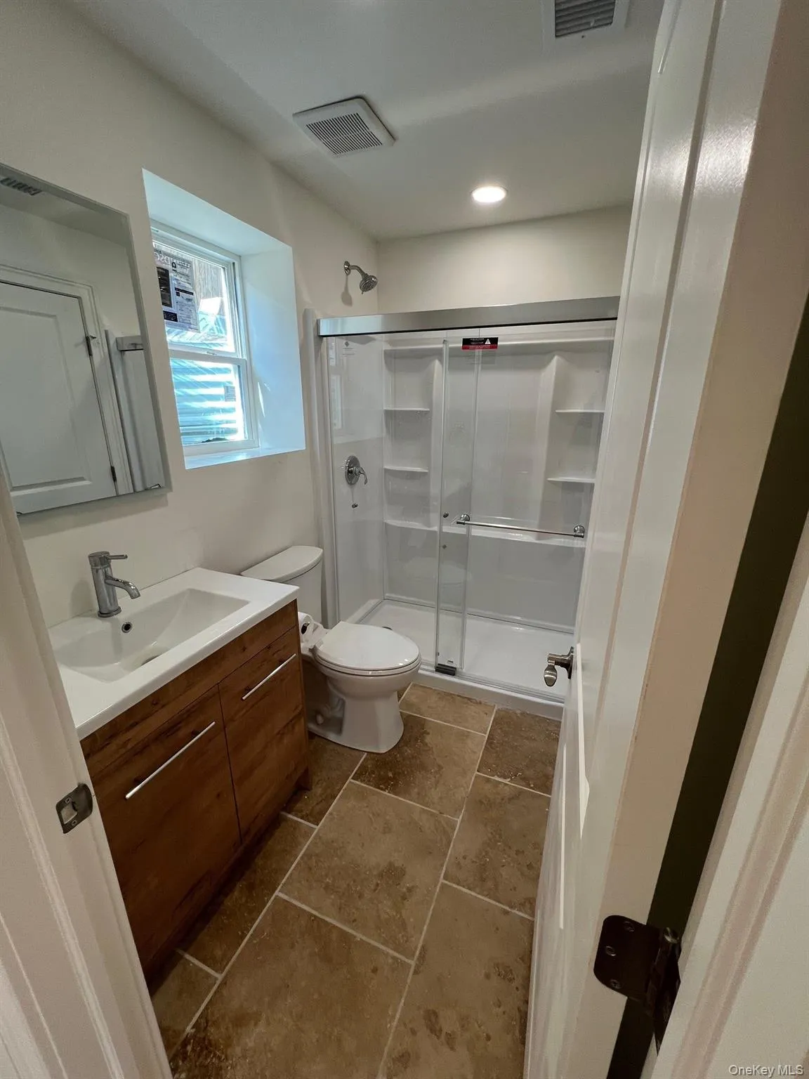 Full bath with a shower stall, vanity, visible vents, and toilet Full bath with a shower stall, vanity, visible vents, and toilet