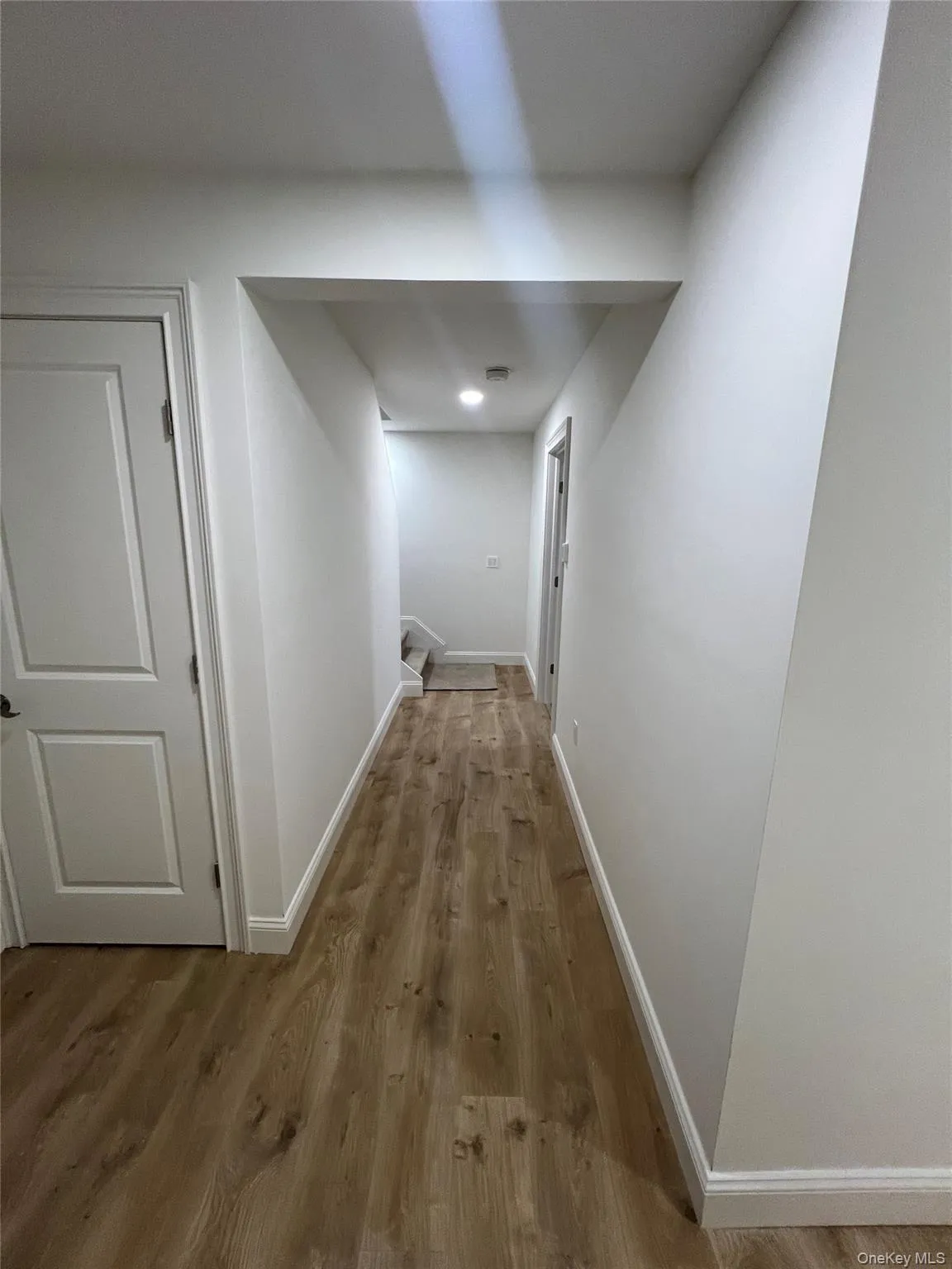 Hallway with wood finished floors and baseboards Hallway with wood finished floors and baseboards