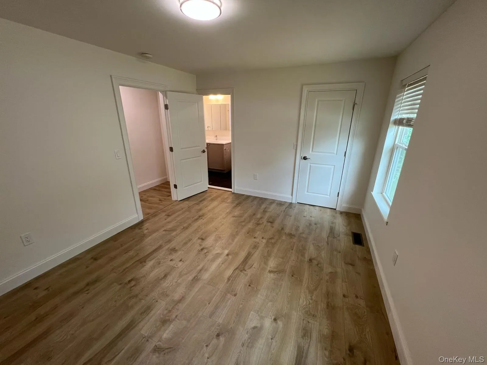 Unfurnished bedroom featuring wood finished floors and ensuite bathroom Unfurnished bedroom featuring wood finished floors and ensuite bathroom