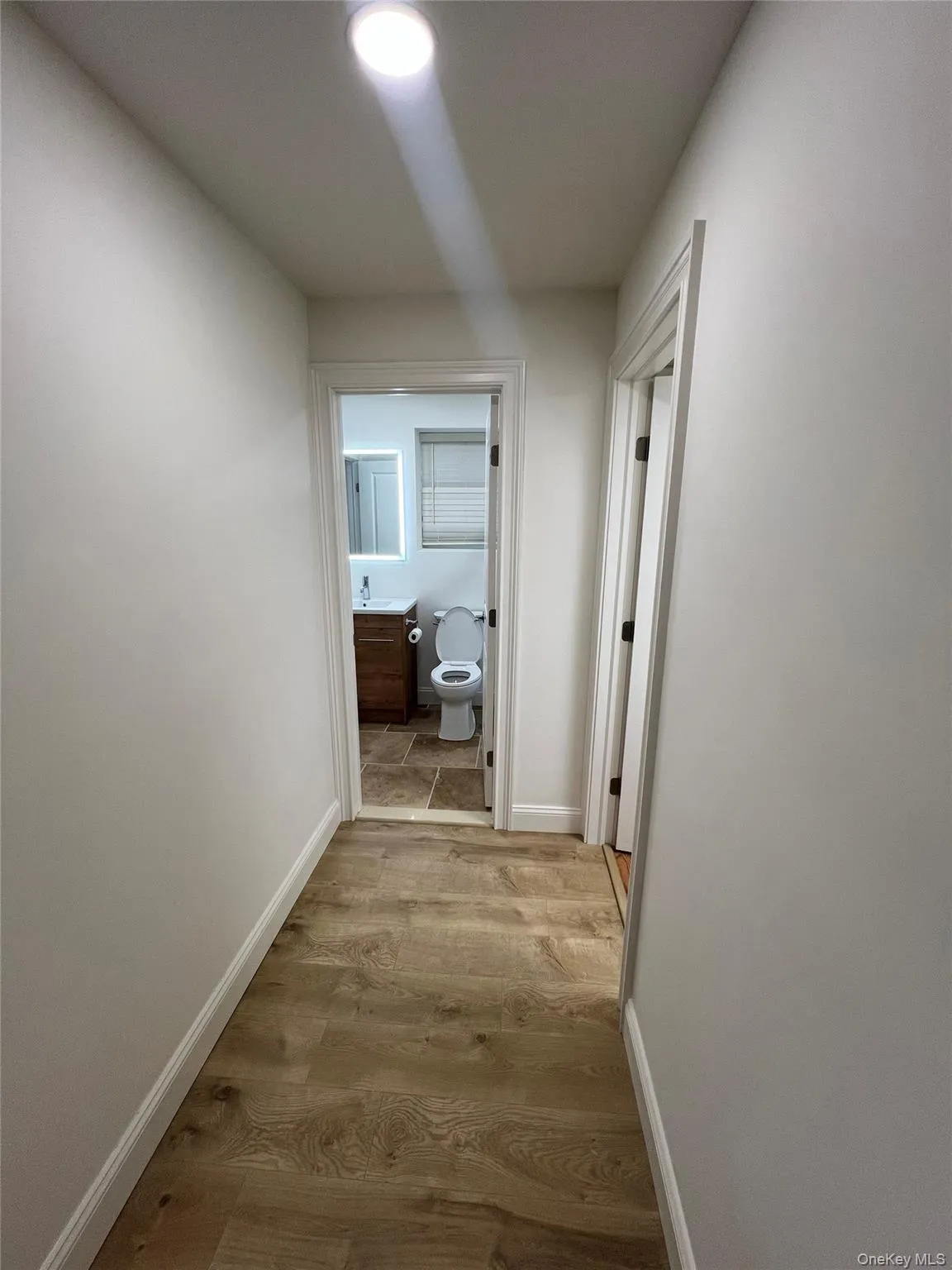 Hallway featuring wood finished floors and baseboards Hallway featuring wood finished floors and baseboards