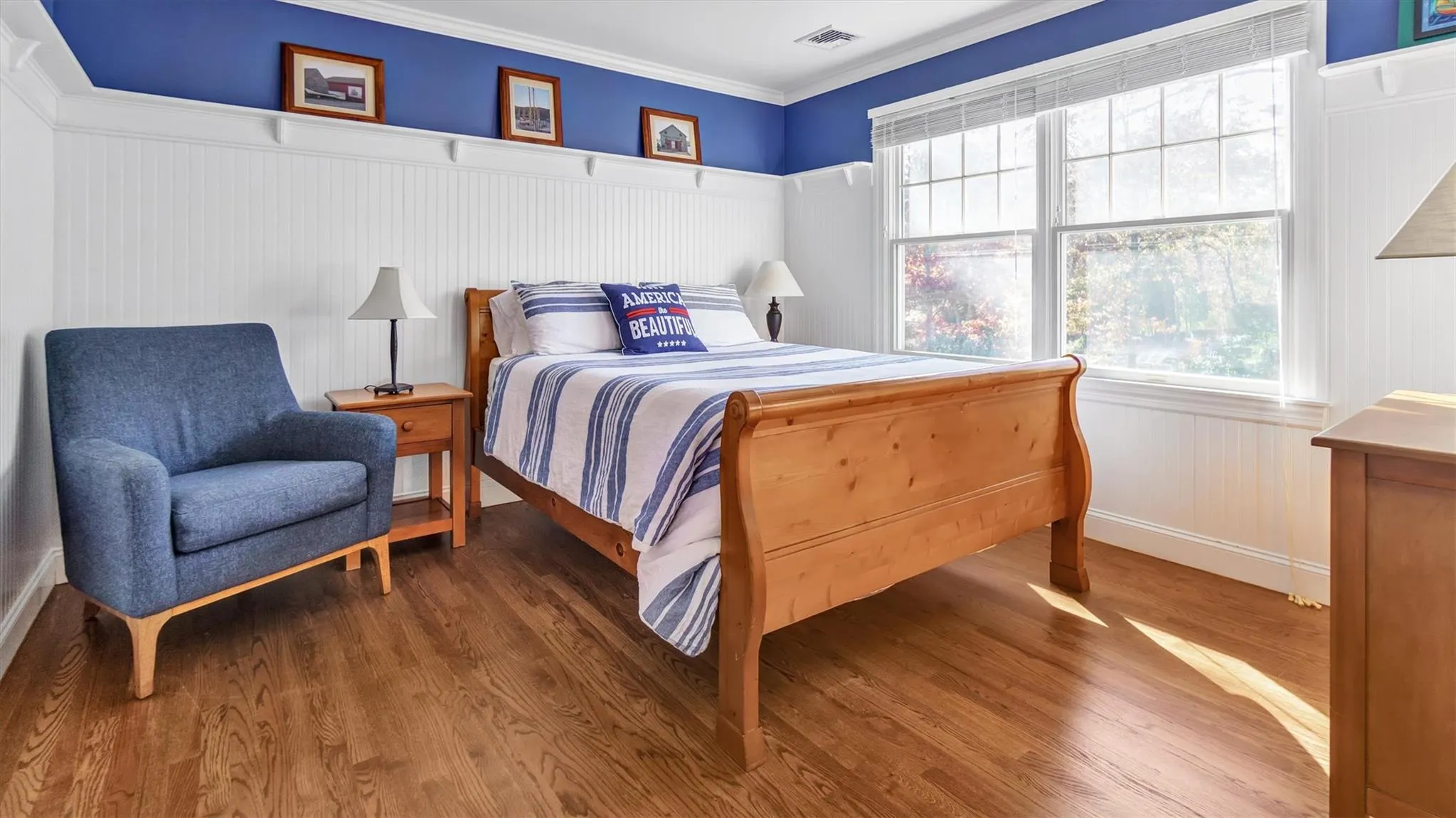 Bedroom with visible vents, multiple windows, crown molding, and wood finished floors Bedroom with visible vents, multiple windows, crown molding, and wood finished floors