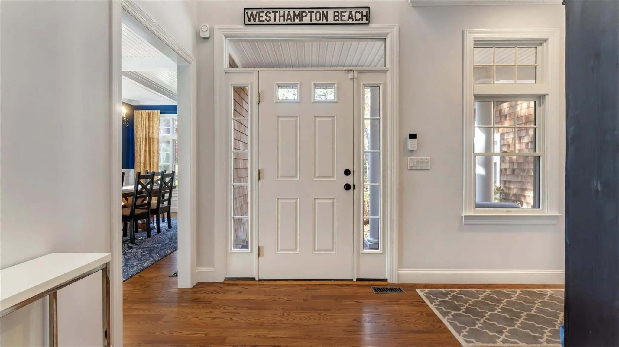 Foyer entrance featuring visible vents, baseboards, and wood finished floors Foyer entrance featuring visible vents, baseboards, and wood finished floors