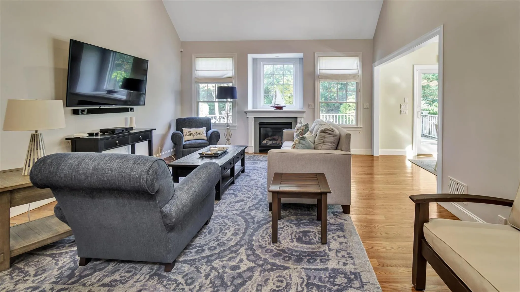 Living area featuring vaulted ceiling, wood finished floors, and a healthy amount of sunlight Living area featuring vaulted ceiling, wood finished floors, and a healthy amount of sunlight
