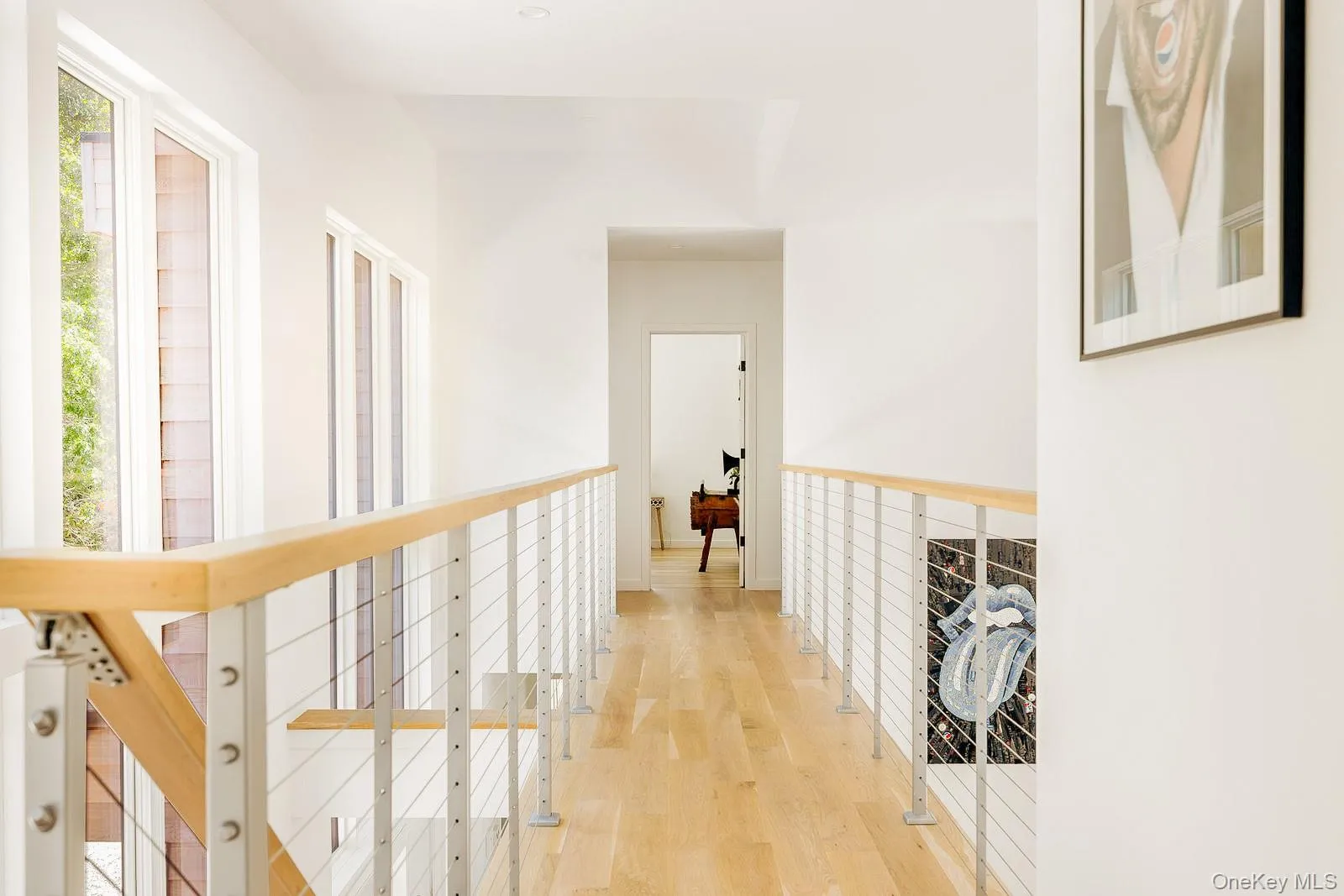 Hallway with an upstairs landing and light wood-type flooring Hallway with an upstairs landing and light wood-type flooring