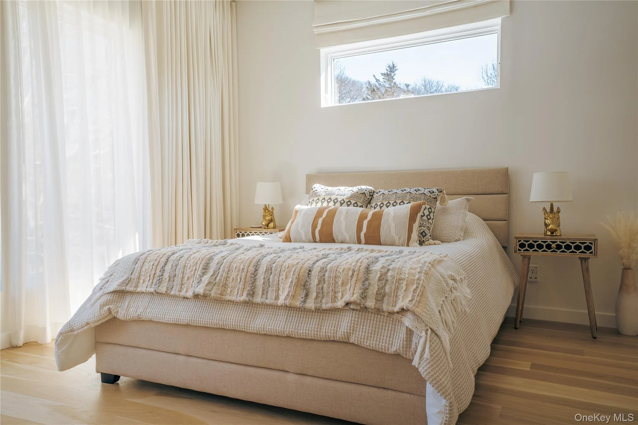 Bedroom featuring wood finished floors and baseboards Bedroom featuring wood finished floors and baseboards