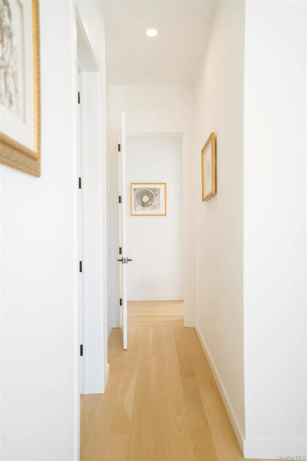 Corridor with light wood finished floors, recessed lighting, and baseboards Corridor with light wood finished floors, recessed lighting, and baseboards