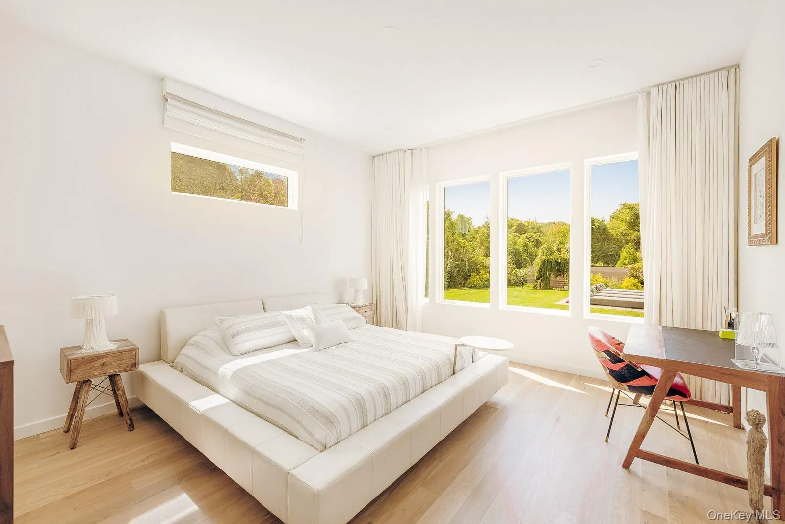 Bedroom with multiple windows, baseboards, and light wood-style floors Bedroom with multiple windows, baseboards, and light wood-style floors