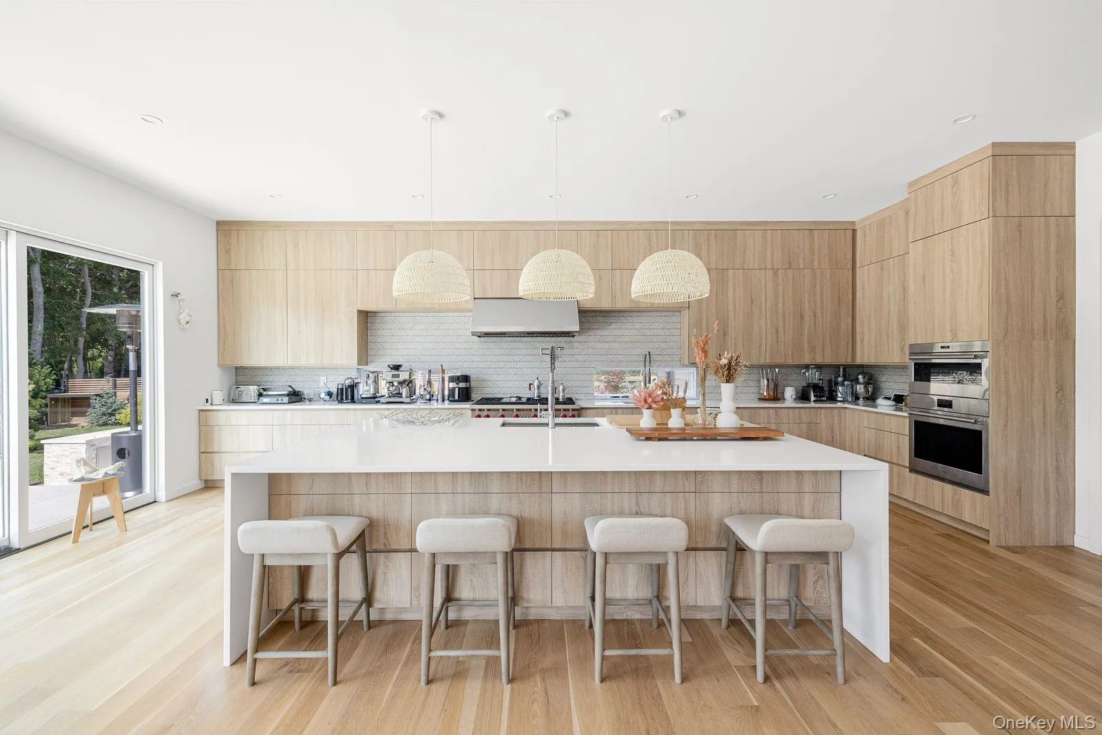 Kitchen featuring a breakfast bar, modern cabinets, light wood-style floors, and stainless steel double oven Kitchen featuring a breakfast bar, modern cabinets, light wood-style floors, and stainless steel double oven