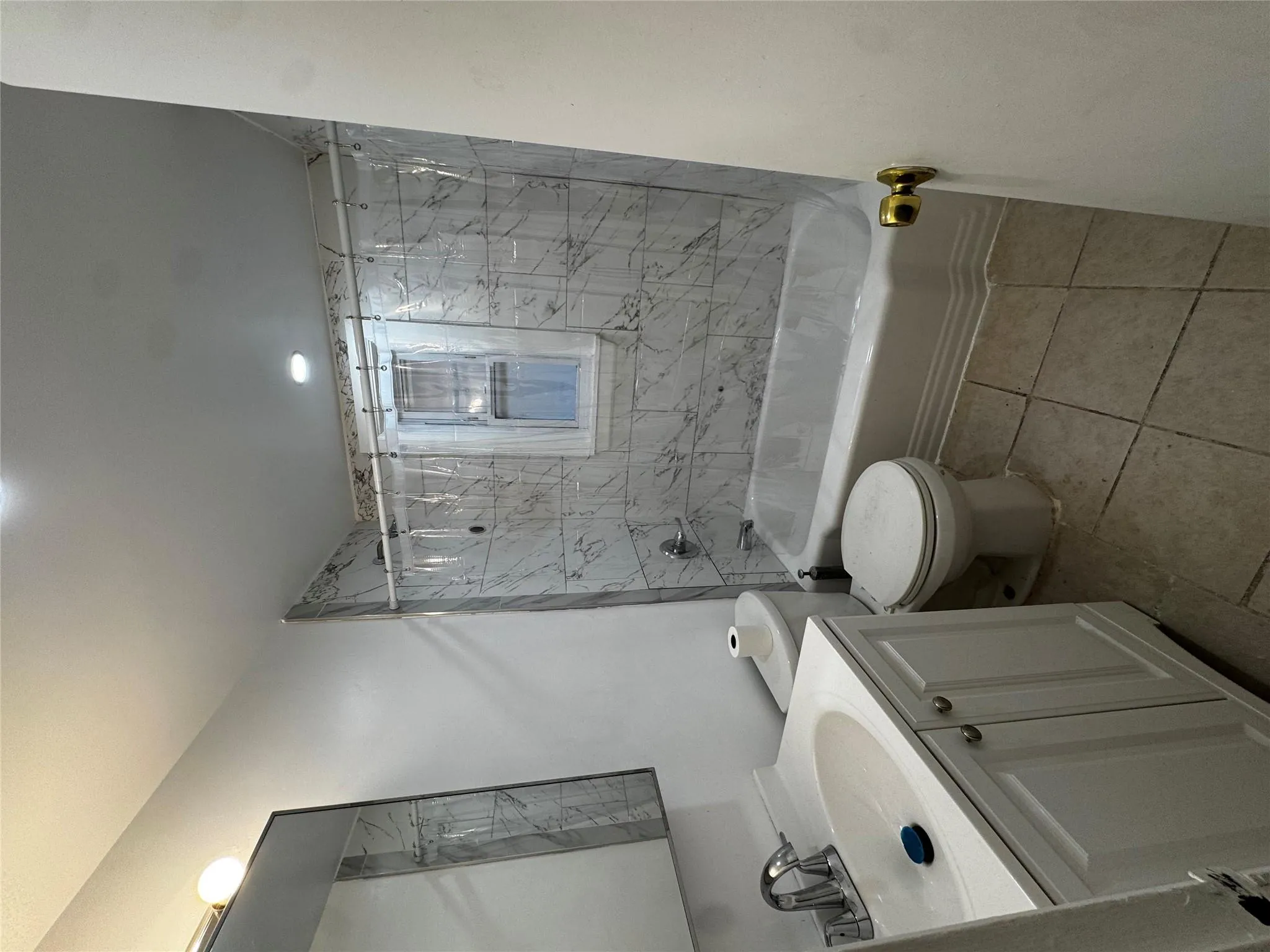 Bathroom featuring tile patterned floors, washtub / shower combination, toilet, and vanity Bathroom featuring tile patterned floors, washtub / shower combination, toilet, and vanity