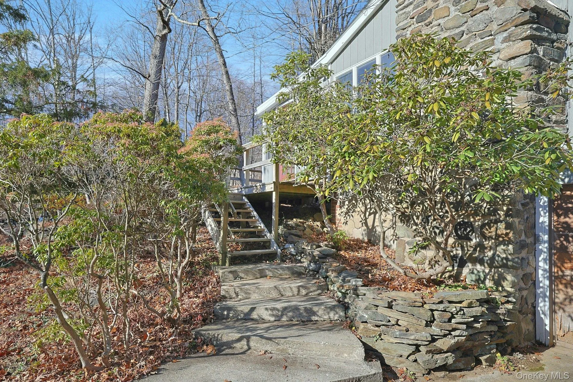 Flanked by a stacked stone wall and plantings, the pathway and steps lead to the front entrance Flanked by a stacked stone wall and plantings, the pathway and steps lead to the front entrance