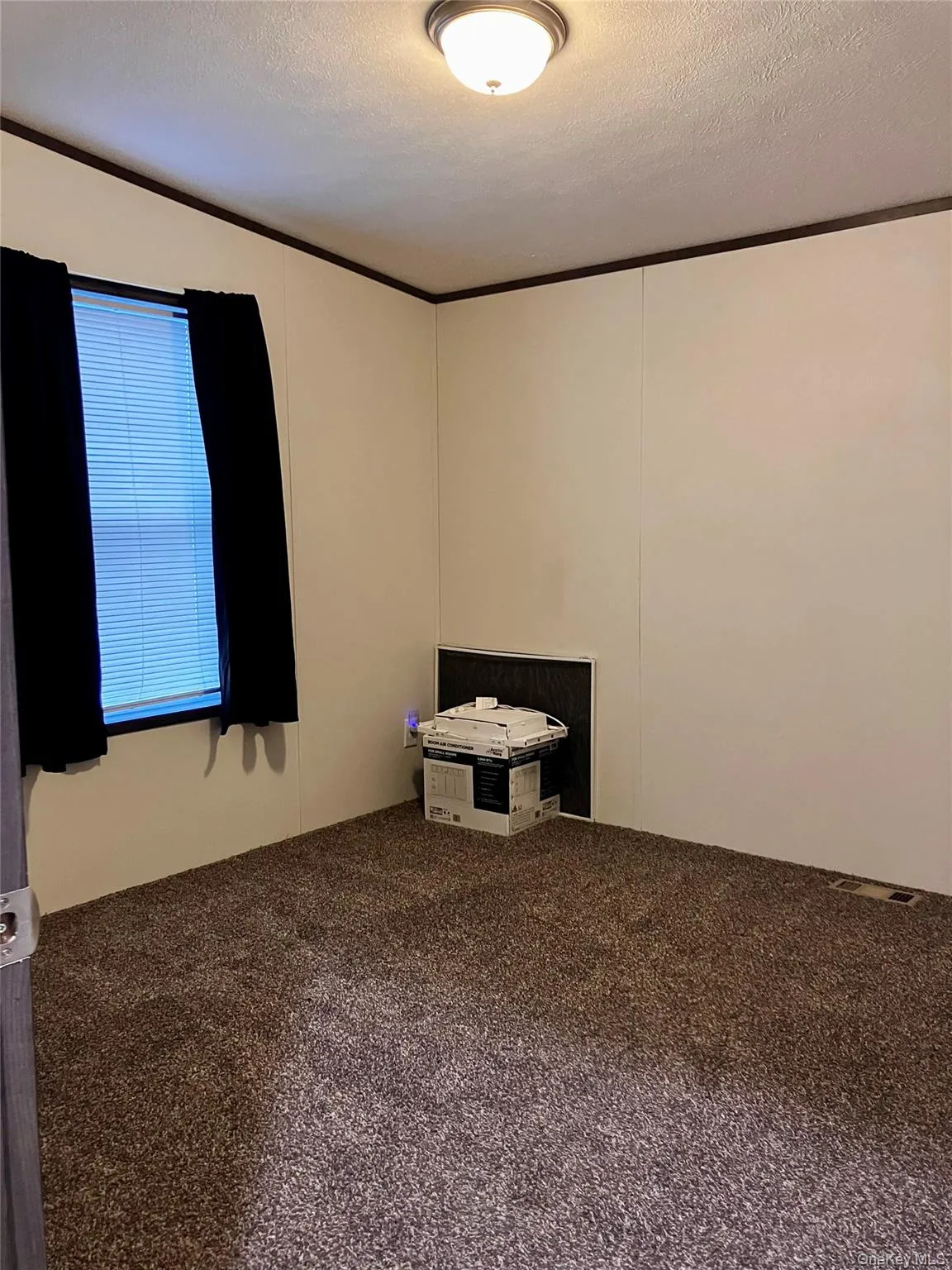 Unfurnished room with ornamental molding, carpet, and a textured ceiling Unfurnished room with ornamental molding, carpet, and a textured ceiling