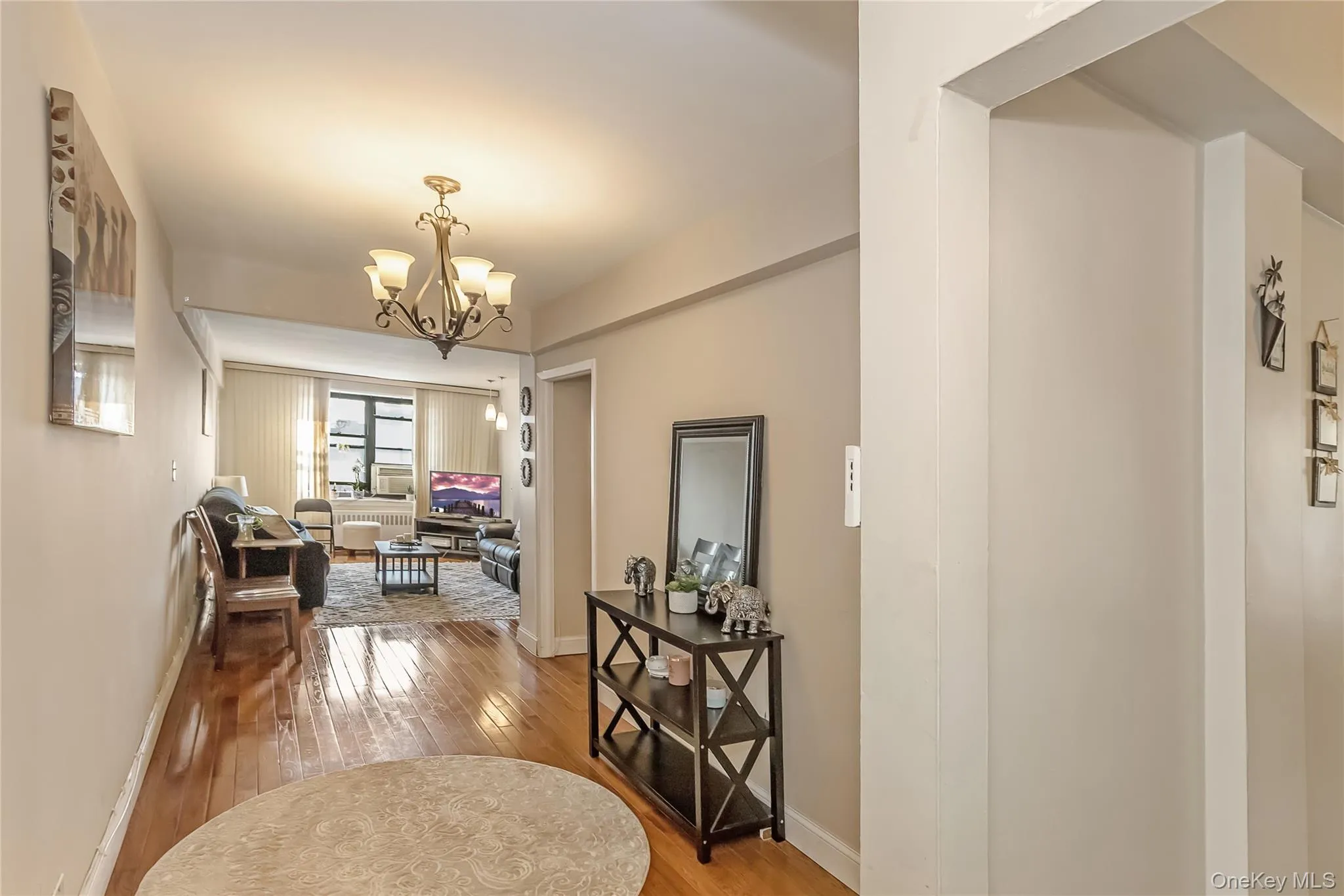 Hall with a chandelier, baseboards, and hardwood / wood-style floors Hall with a chandelier, baseboards, and hardwood / wood-style floors