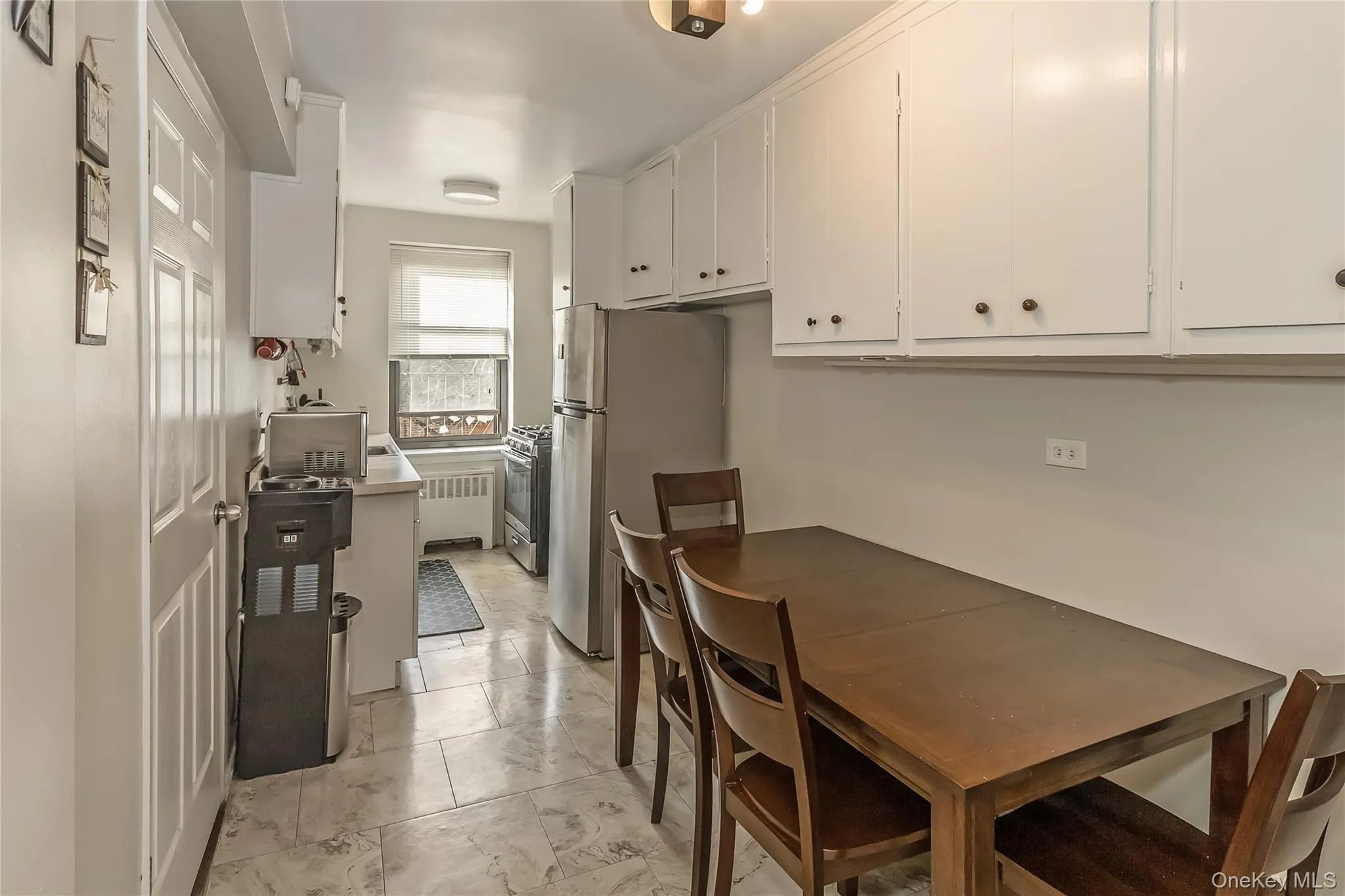 Dining area featuring radiator and marble finish floor Dining area featuring radiator and marble finish floor