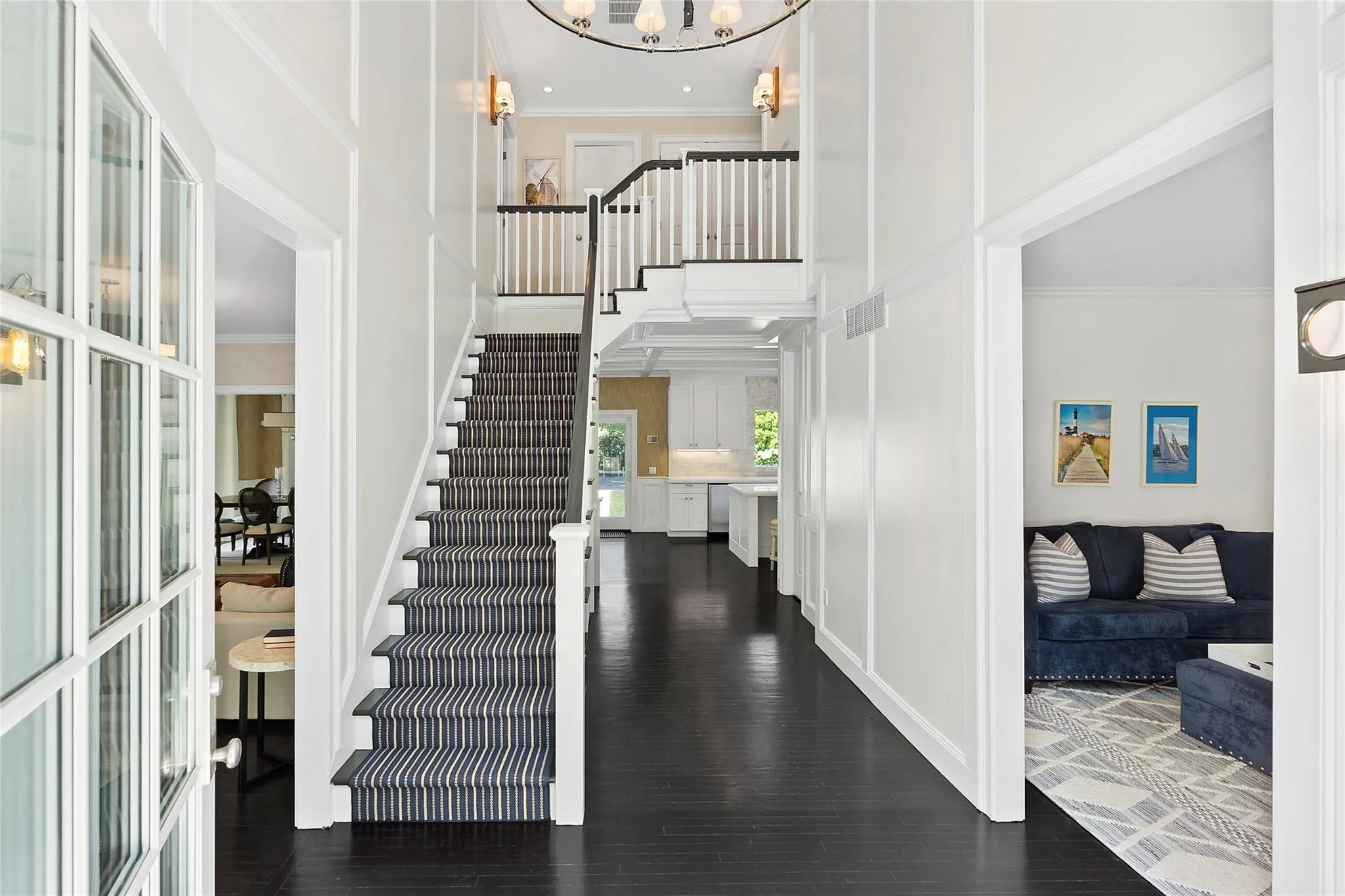 Foyer entrance with visible vents, dark wood-type flooring, stairway, crown molding, and a towering ceiling Foyer entrance with visible vents, dark wood-type flooring, stairway, crown molding, and a towering ceiling