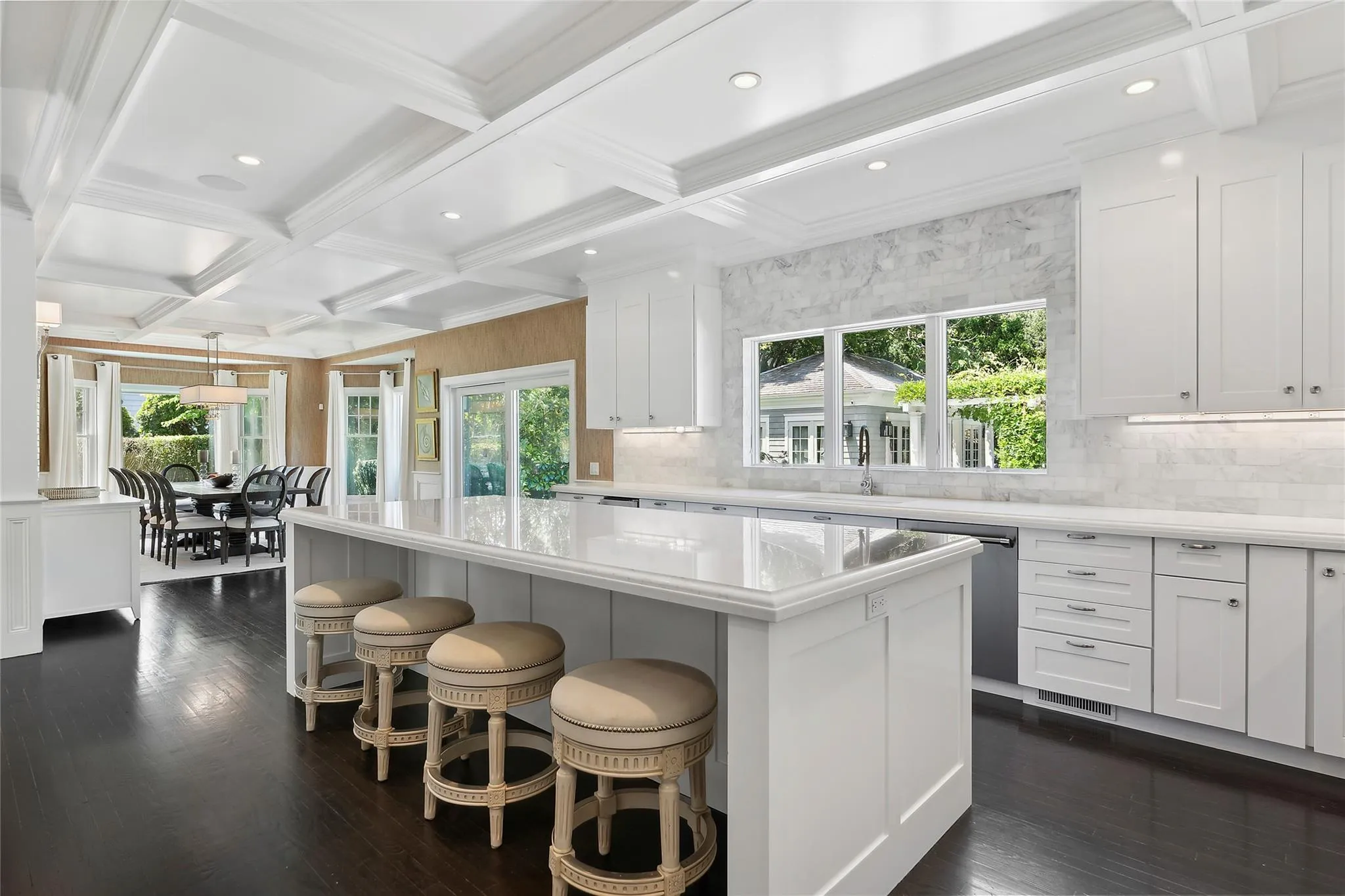 Kitchen featuring stainless steel dishwasher, dark wood finished floors, a center island, and coffered ceiling Kitchen featuring stainless steel dishwasher, dark wood finished floors, a center island, and coffered ceiling