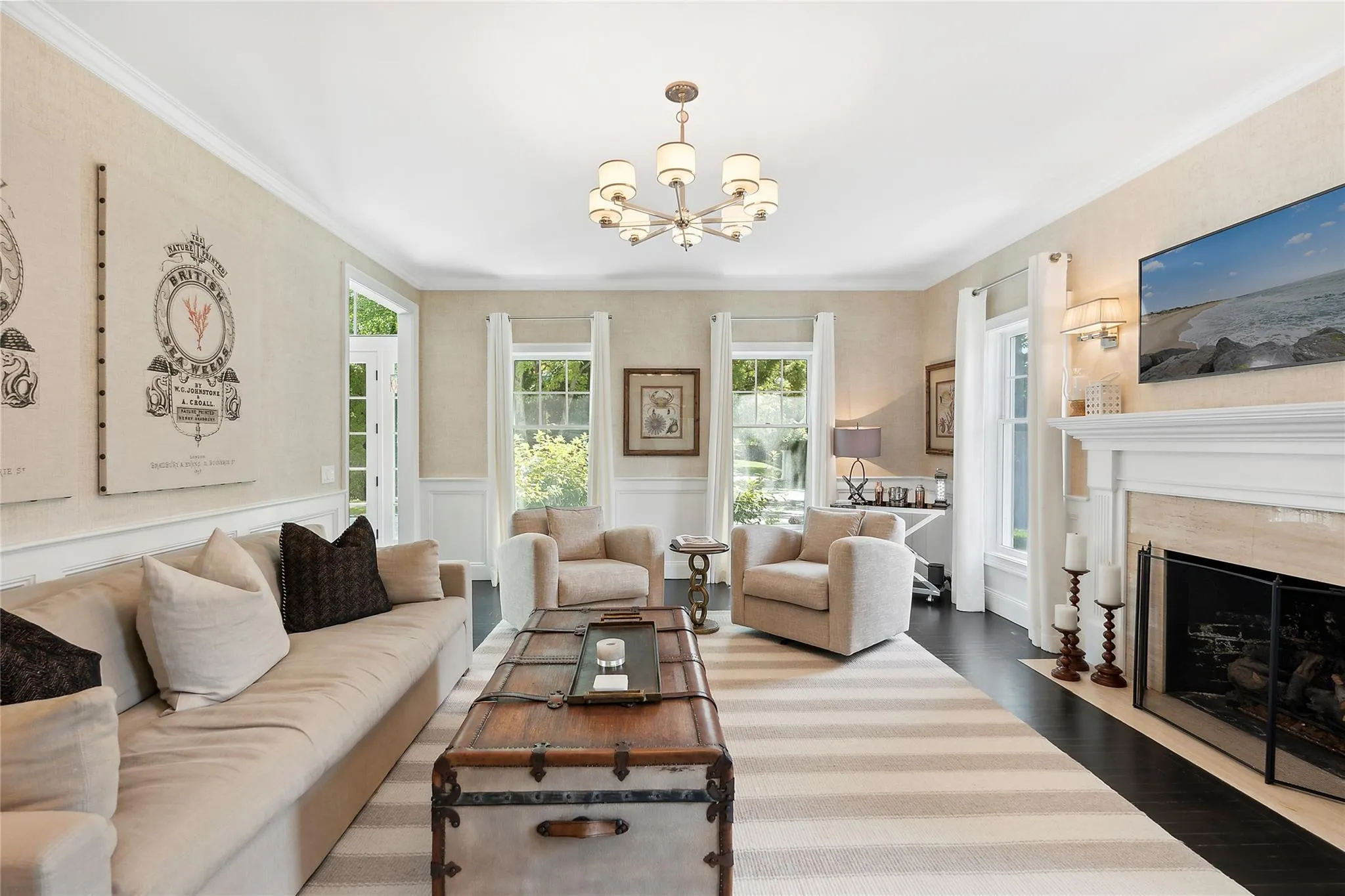 Living room with wood finished floors, wainscoting, and crown molding Living room with wood finished floors, wainscoting, and crown molding