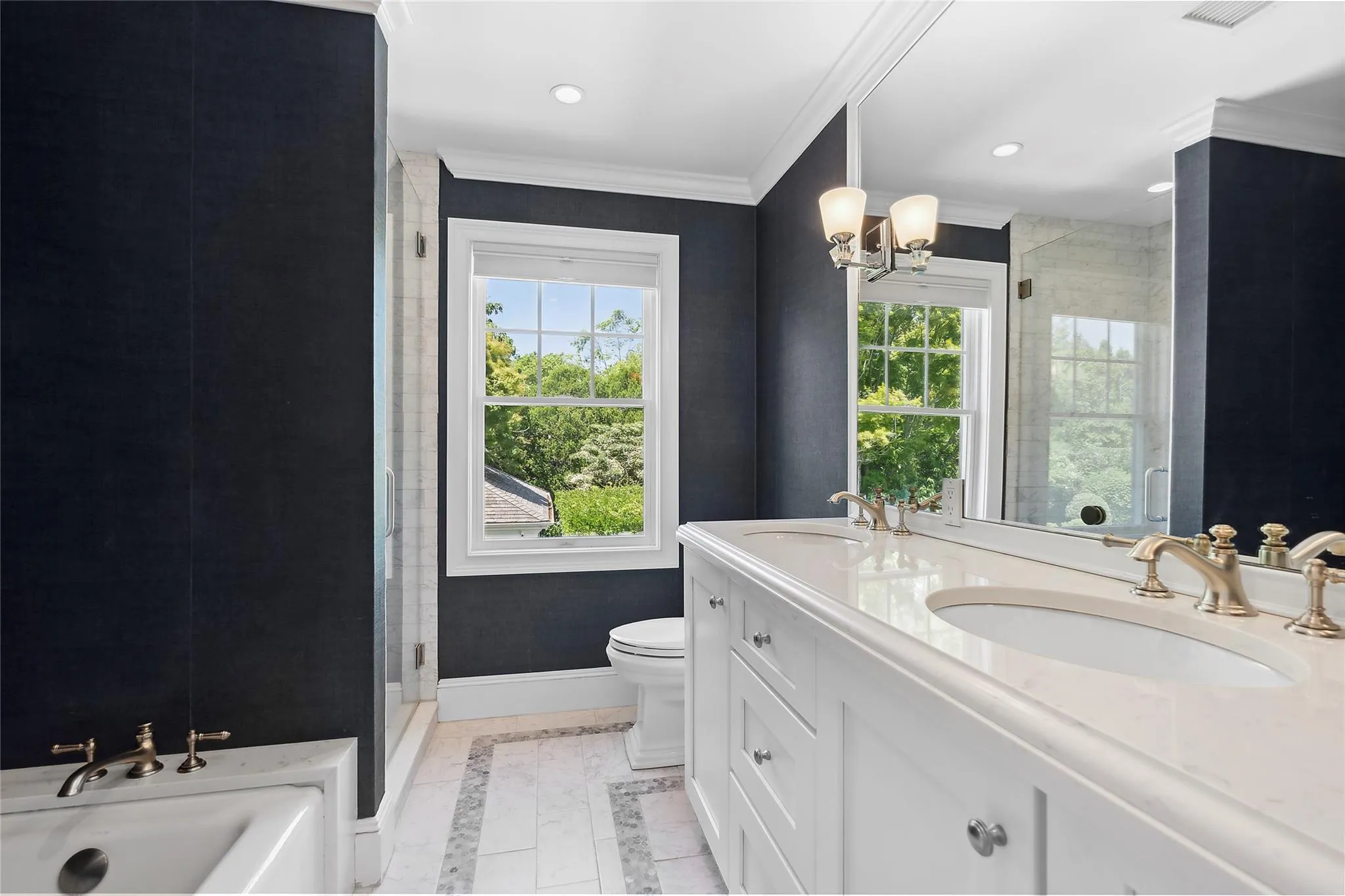 Bathroom with a shower stall, baseboards, toilet, a notable chandelier, and a sink Bathroom with a shower stall, baseboards, toilet, a notable chandelier, and a sink