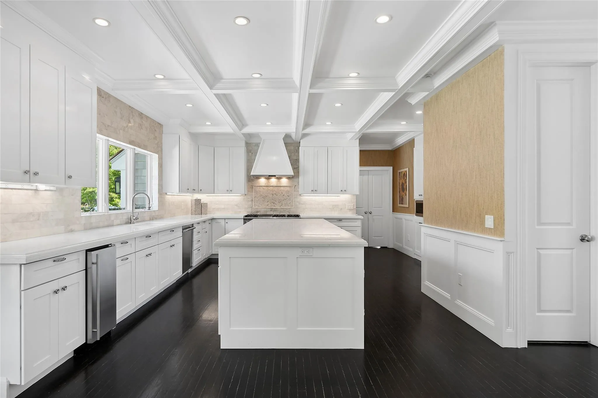 Kitchen featuring beam ceiling, light countertops, custom range hood, white cabinetry, and range Kitchen featuring beam ceiling, light countertops, custom range hood, white cabinetry, and range