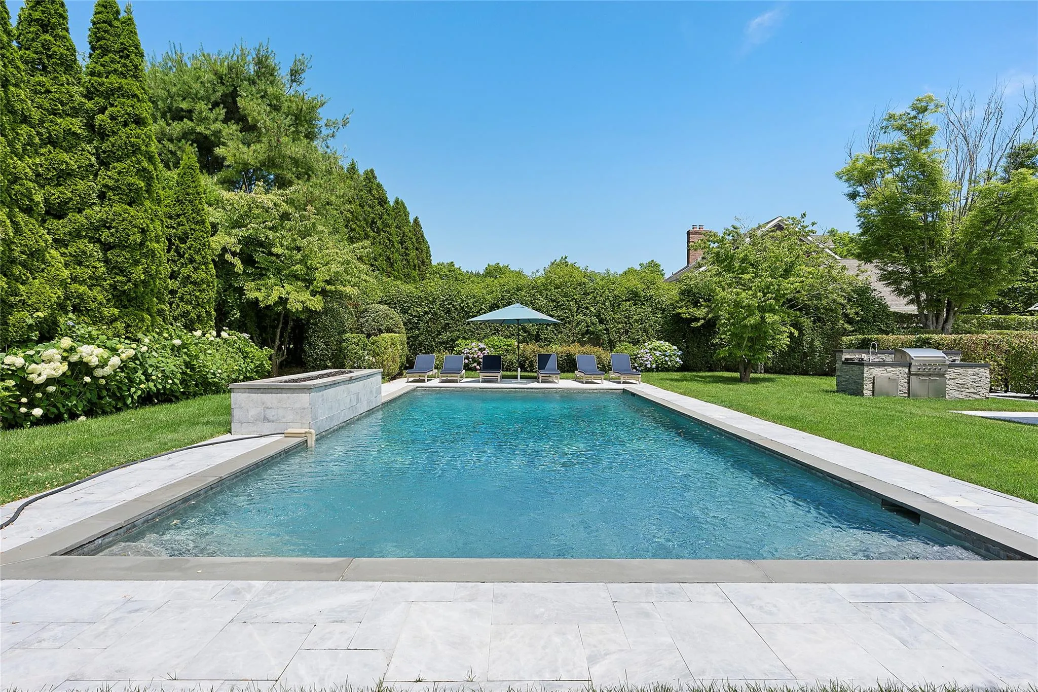 Outdoor pool with an outdoor kitchen, a lawn, and a patio Outdoor pool with an outdoor kitchen, a lawn, and a patio