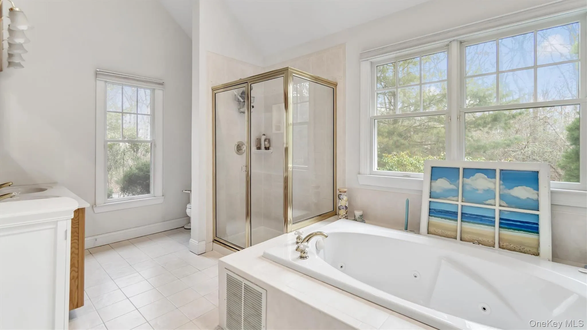 Full bath featuring lofted ceiling, a whirlpool tub, tile patterned flooring, a shower stall, and toilet Full bath featuring lofted ceiling, a whirlpool tub, tile patterned flooring, a shower stall, and toilet