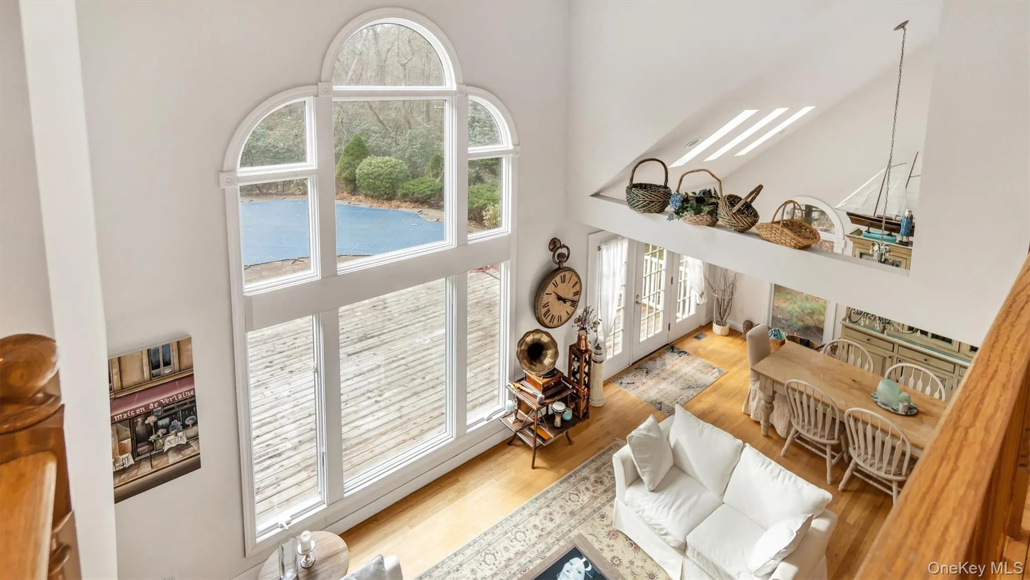 Living area with a high ceiling and wood finished floors Living area with a high ceiling and wood finished floors