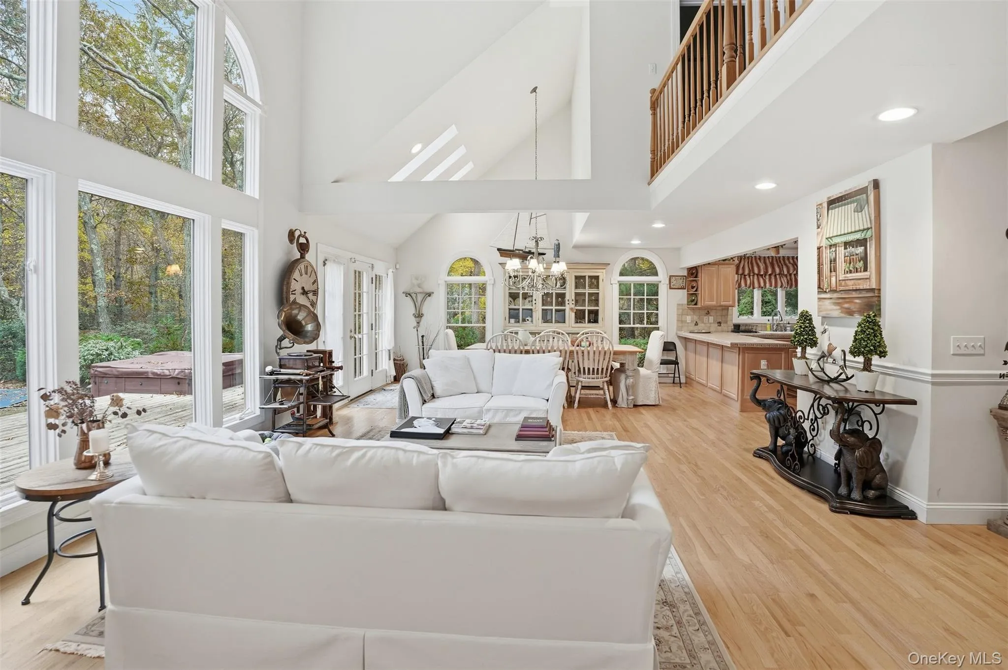 Living area featuring a high ceiling, light wood-type flooring, a chandelier, french doors, and recessed lighting Living area featuring a high ceiling, light wood-type flooring, a chandelier, french doors, and recessed lighting