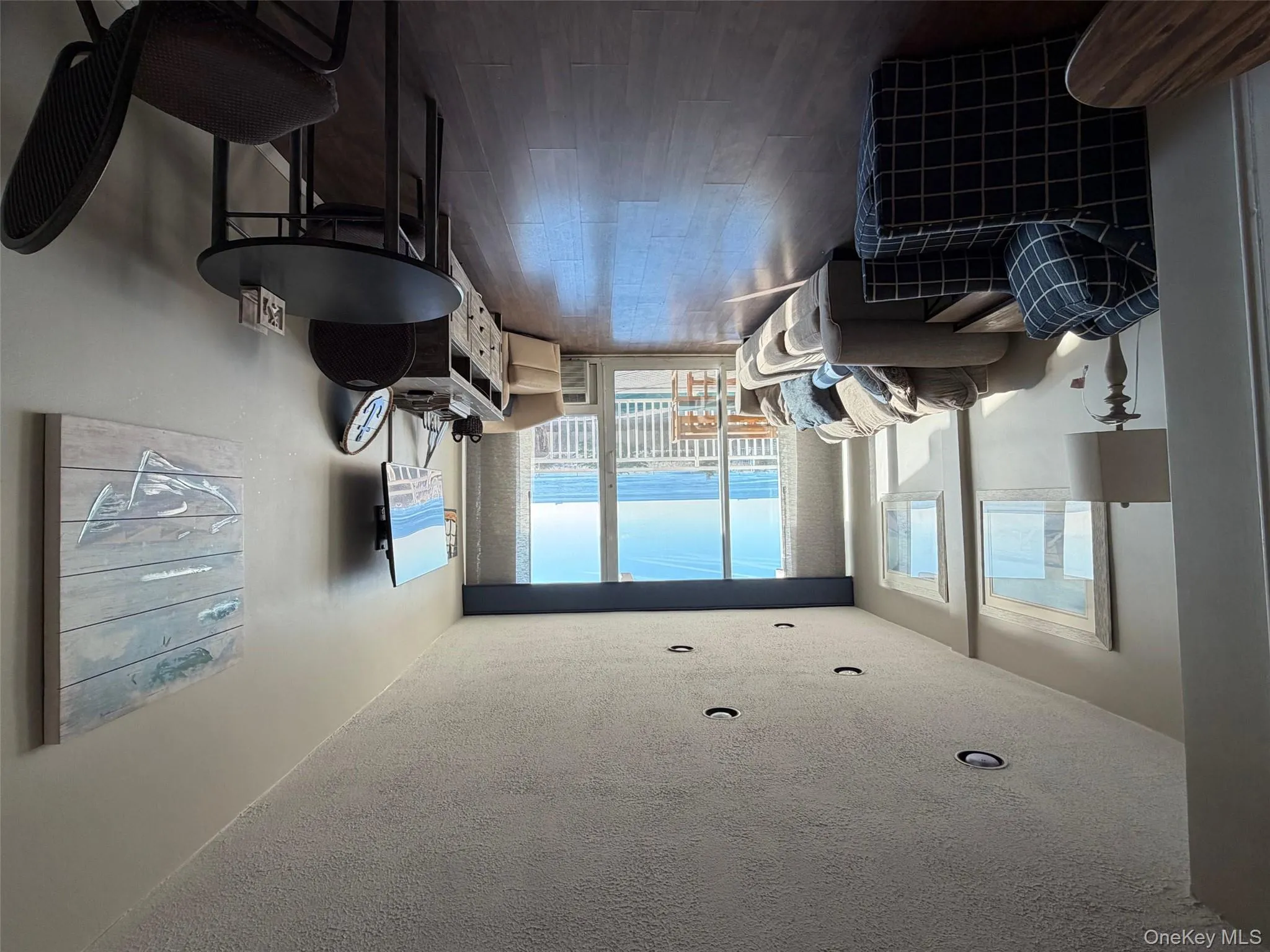 Living area with a textured ceiling, wood finished floors, and expansive windows Living area with a textured ceiling, wood finished floors, and expansive windows