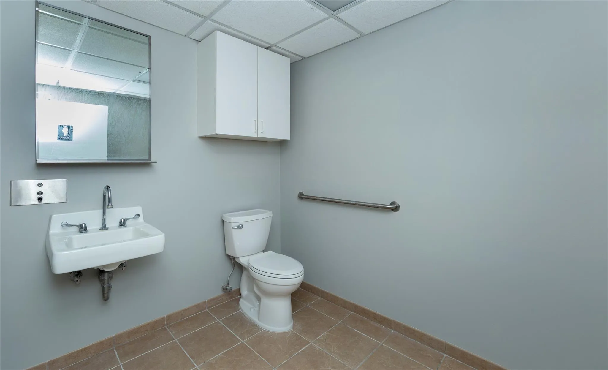Bathroom featuring baseboards, toilet, tile patterned floors, a paneled ceiling, and a sink Bathroom featuring baseboards, toilet, tile patterned floors, a paneled ceiling, and a sink