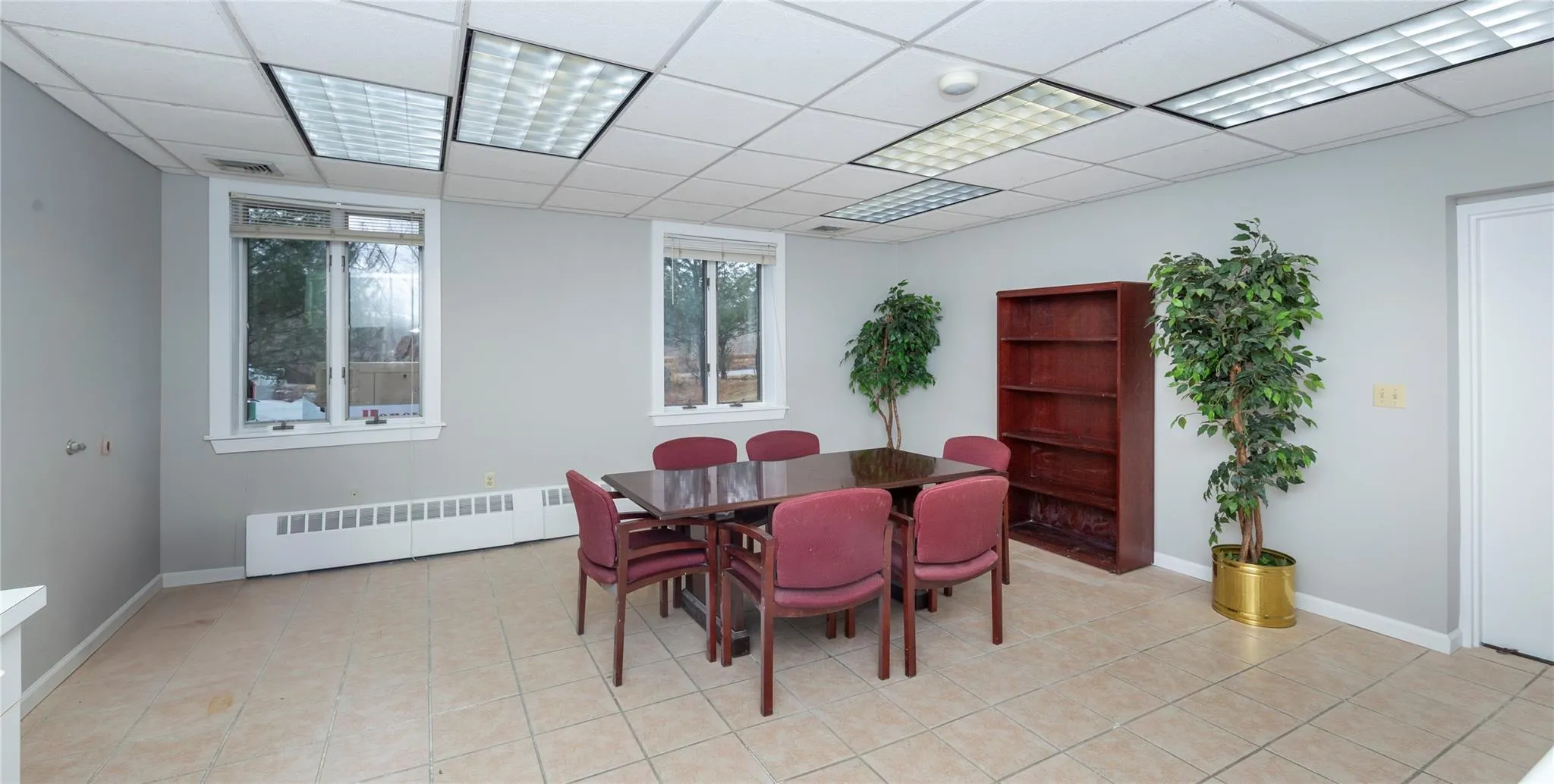 Dining room with radiator, a paneled ceiling, and light tile patterned floors Dining room with radiator, a paneled ceiling, and light tile patterned floors