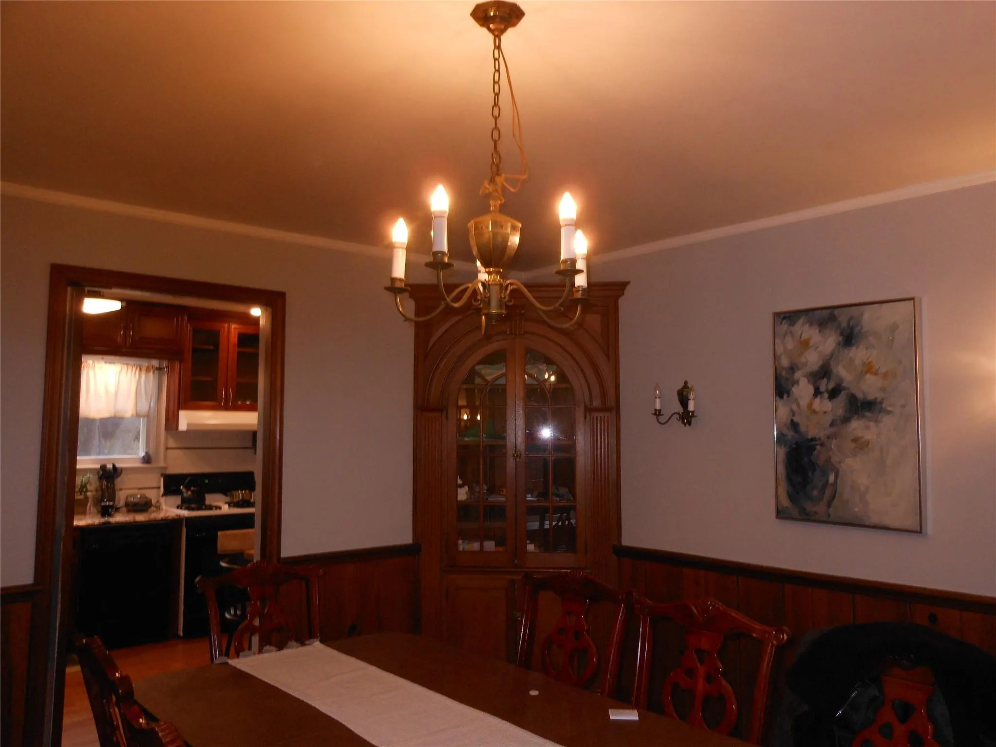 Dining room with an inviting chandelier, ornamental molding, and wainscoting Dining room with an inviting chandelier, ornamental molding, and wainscoting