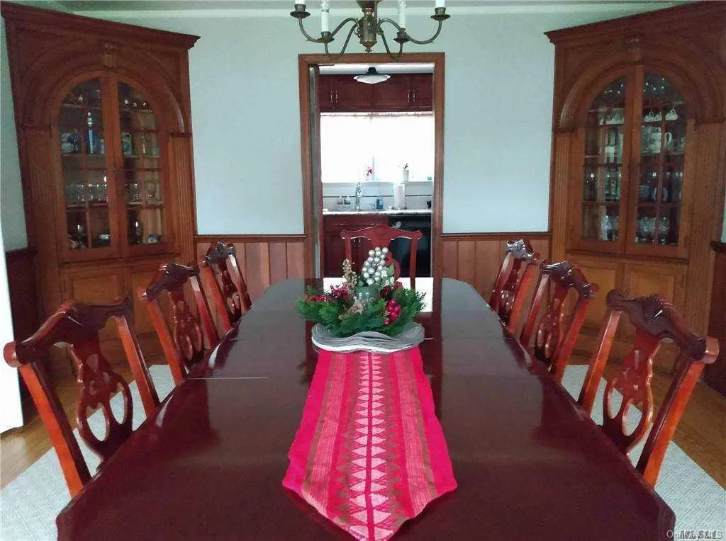 Dining space with an inviting chandelier and a wainscoted wall Dining space with an inviting chandelier and a wainscoted wall
