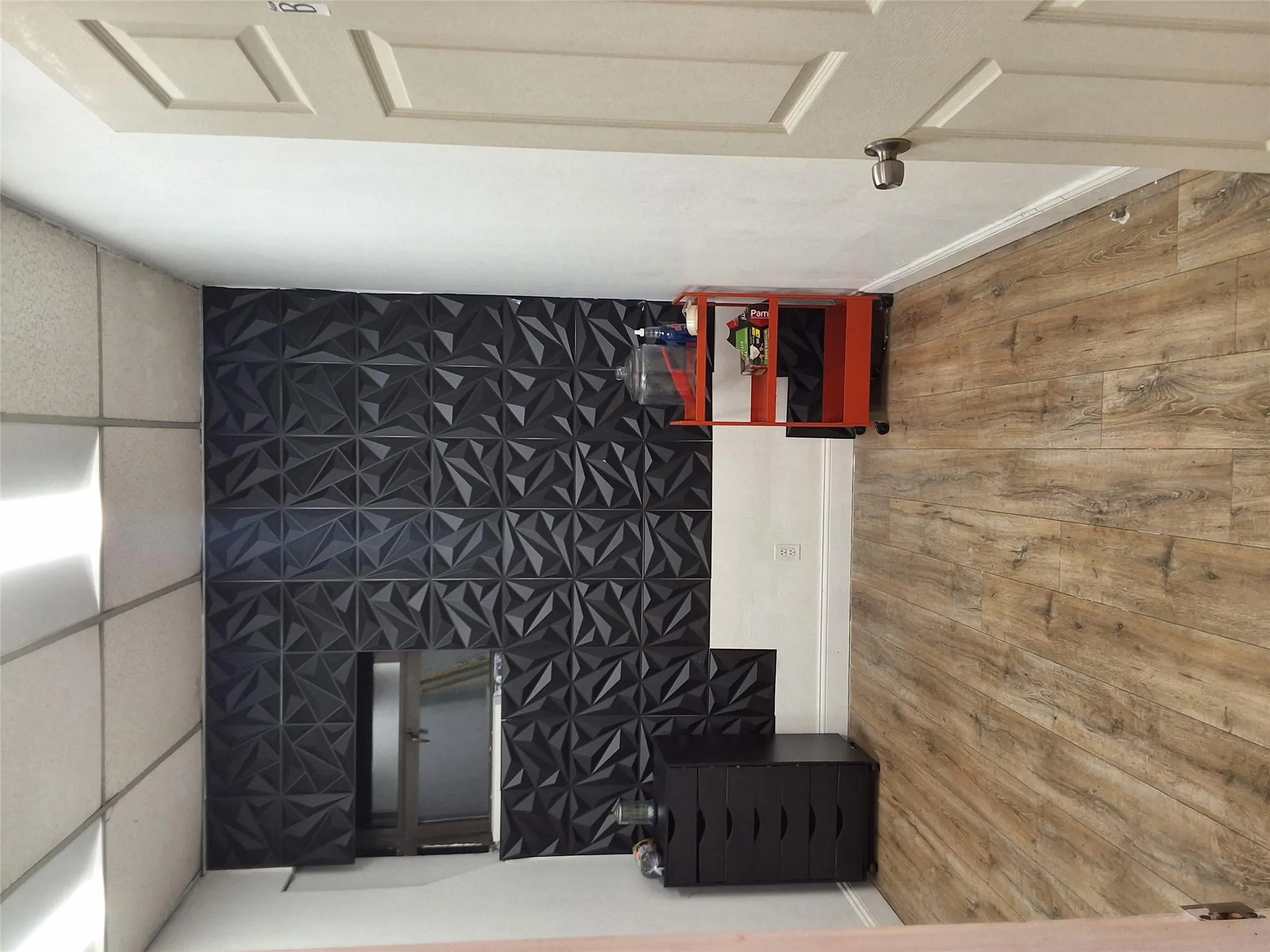 Empty room with a paneled ceiling, wood finished floors, and an accent wall Empty room with a paneled ceiling, wood finished floors, and an accent wall