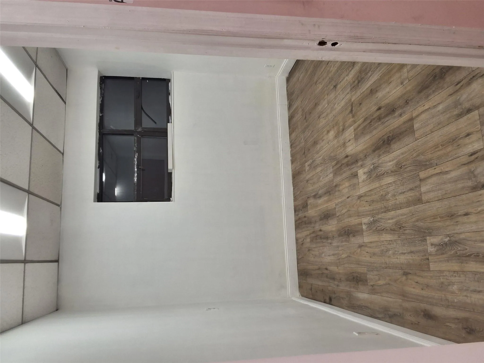 Unfurnished room featuring a drop ceiling, baseboards, and wood finished floors Unfurnished room featuring a drop ceiling, baseboards, and wood finished floors