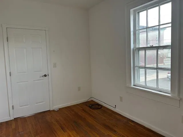 Unfurnished Office featuring wood floors with a door and window Unfurnished Office featuring wood floors with a door and window