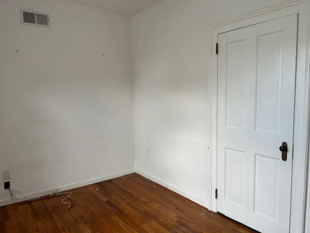 Unfurnished Office featuring wood floors and a separate door Unfurnished Office featuring wood floors and a separate door