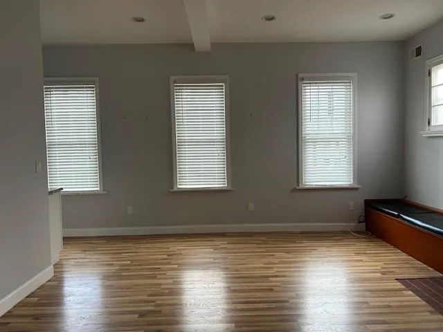 Unfurnished Open Space featuring wood floors, multiple windows with natural light Unfurnished Open Space featuring wood floors, multiple windows with natural light