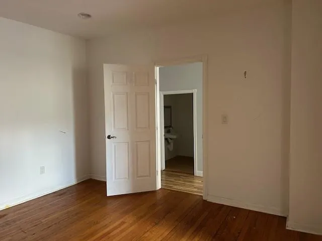 Unfurnished 2nd Office featuring wood floors and a door Unfurnished 2nd Office featuring wood floors and a door