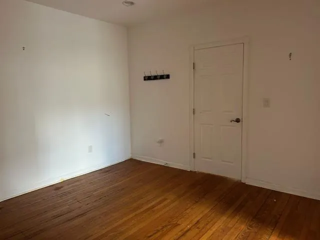 Unfurnished 2nd Office featuring wood floors and a door Unfurnished 2nd Office featuring wood floors and a door